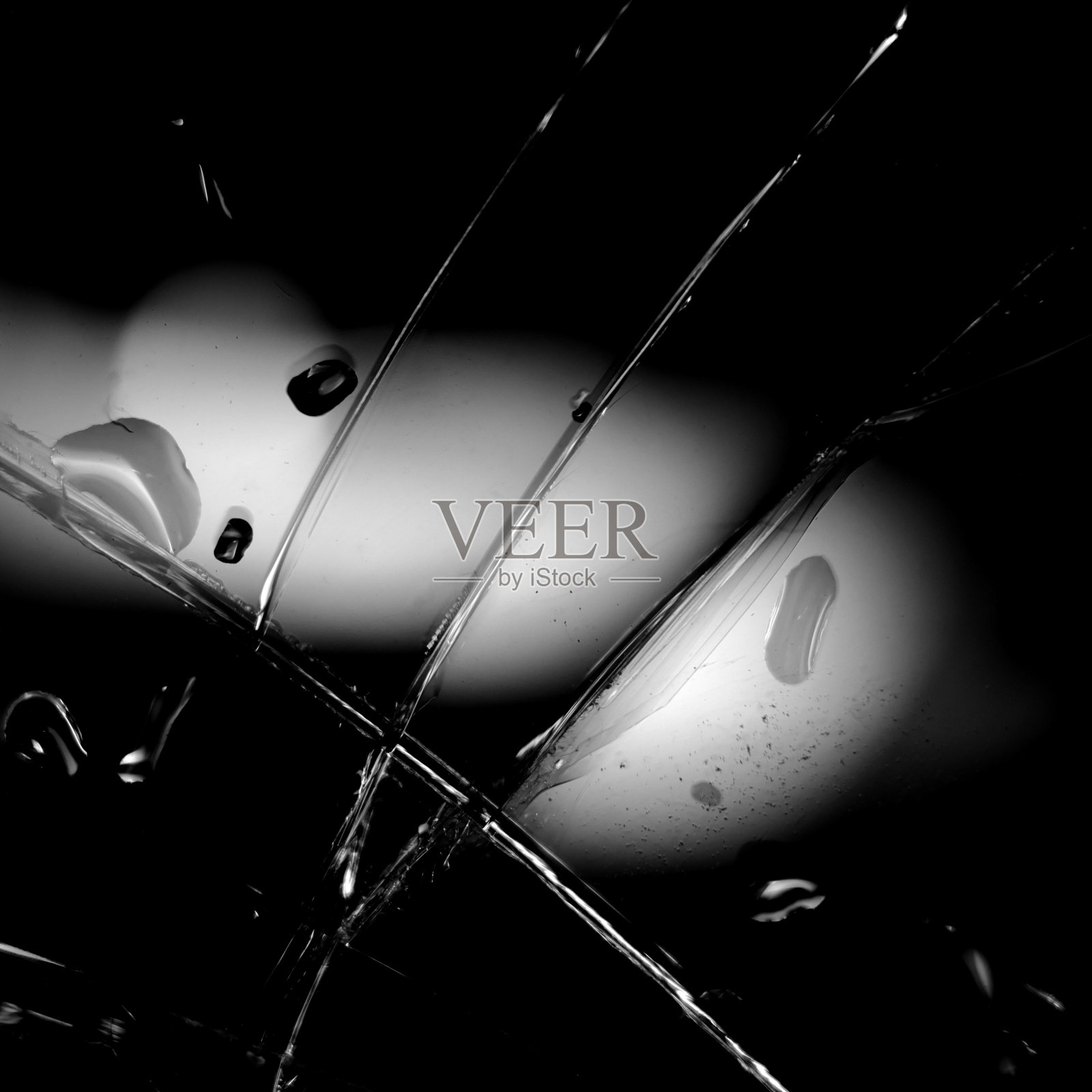 黑色的碎玻璃背景。黑色极简主义背景,玻璃上有裂缝和水滴。抽象的黑色的简约主义。照片摄影图片