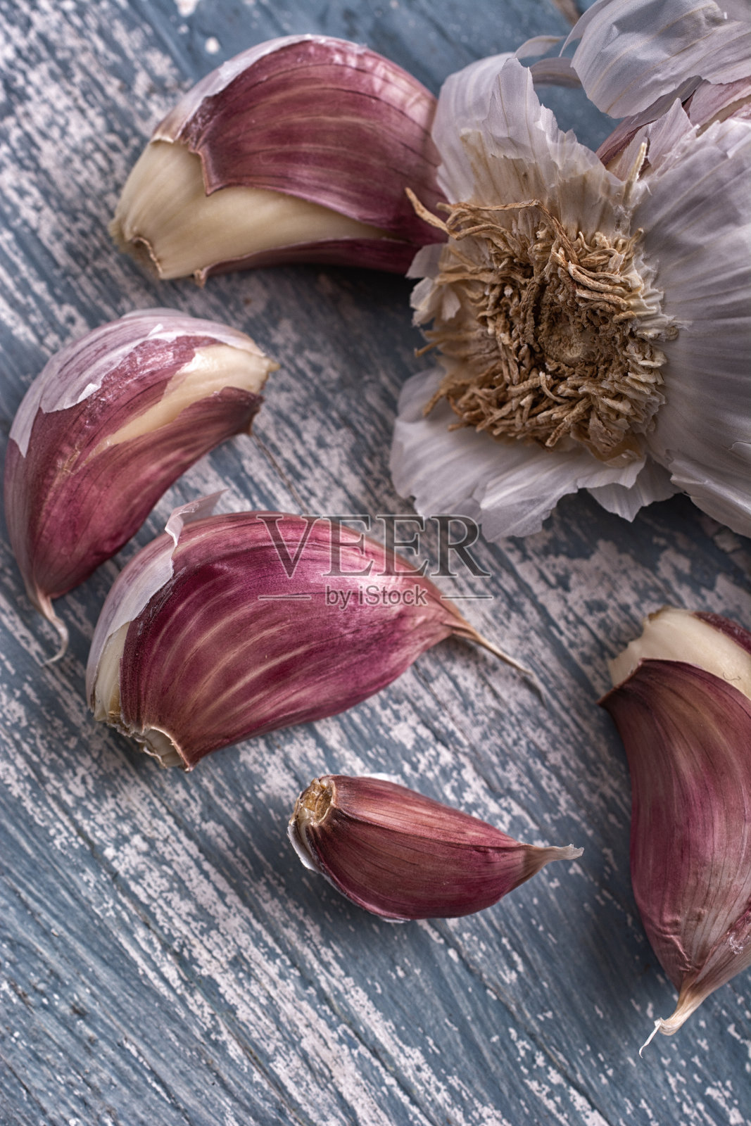 红色的蒜瓣在彩色的木桌上-特写照片摄影图片