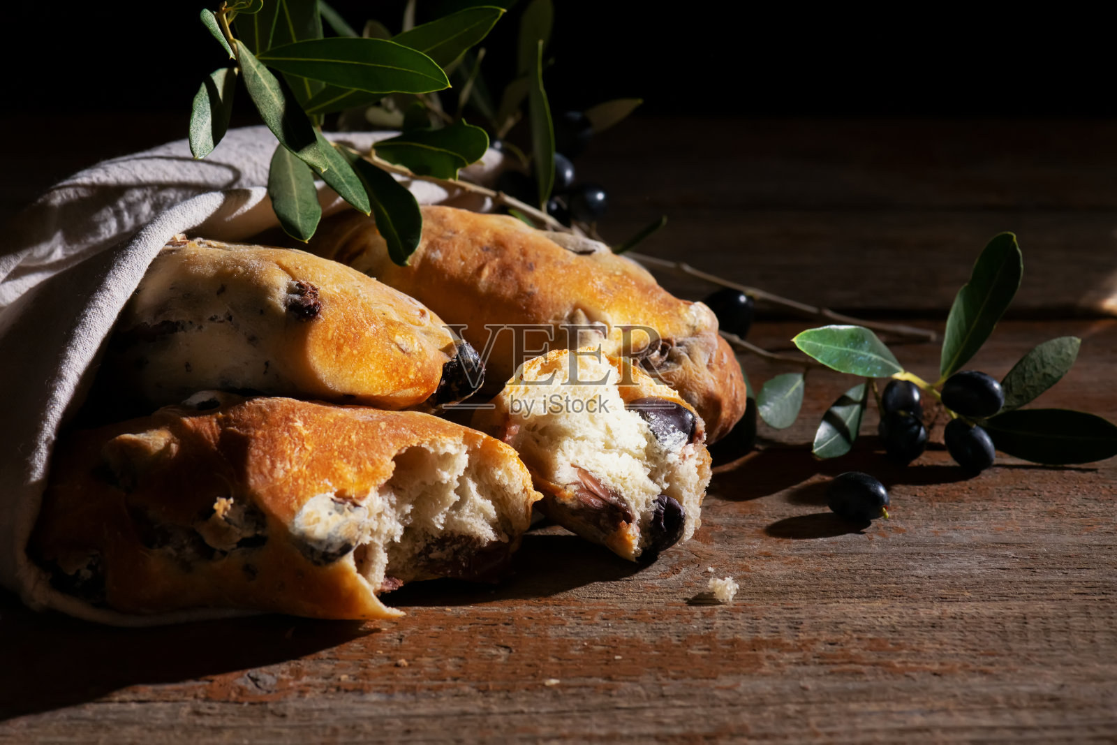 传统的意大利puccia面包与黑橄榄在棉花袋,在萨伦托,普利亚的木制背景照片摄影图片