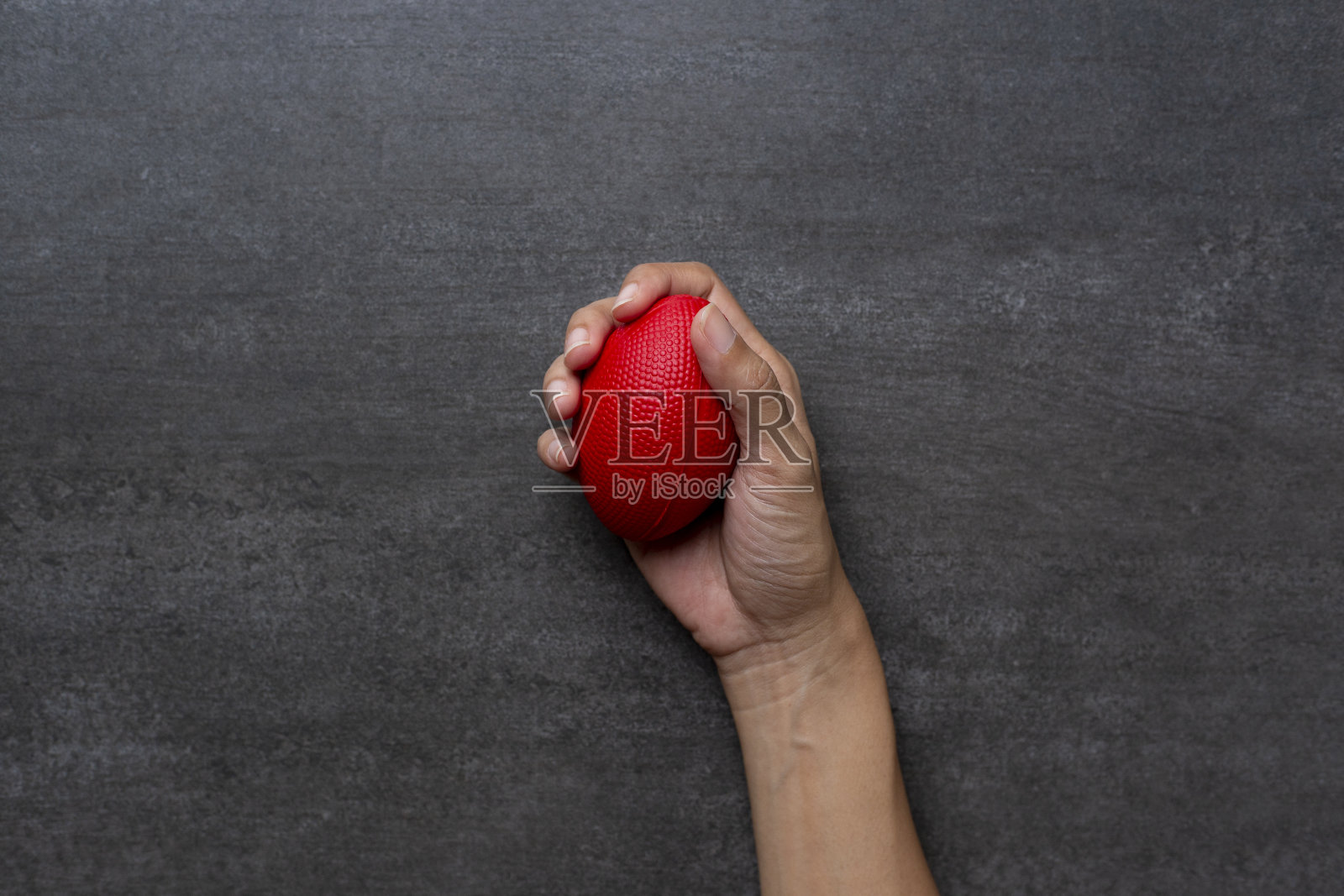 女人手握压力球在黑色桌子的背景照片摄影图片