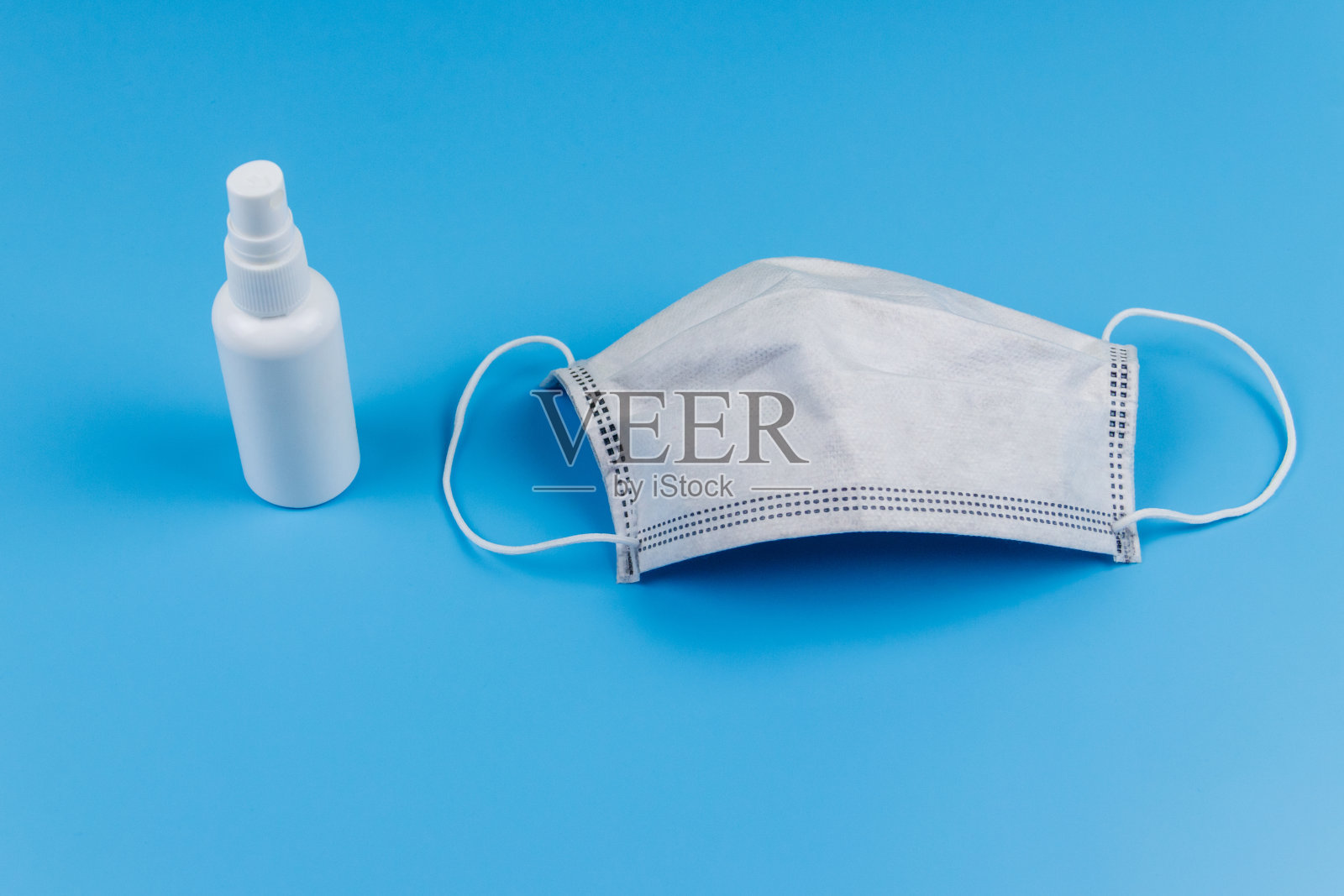医用一次性防护口罩和洗手液,蓝色背景照片摄影图片