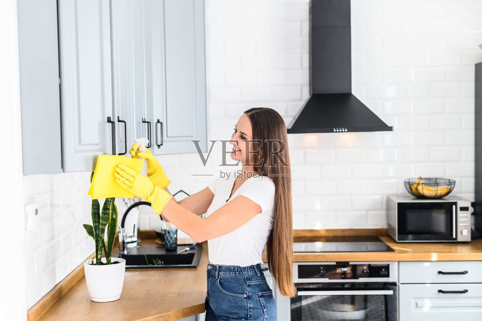 戴着橡胶手套做家务的年轻女子照片摄影图片