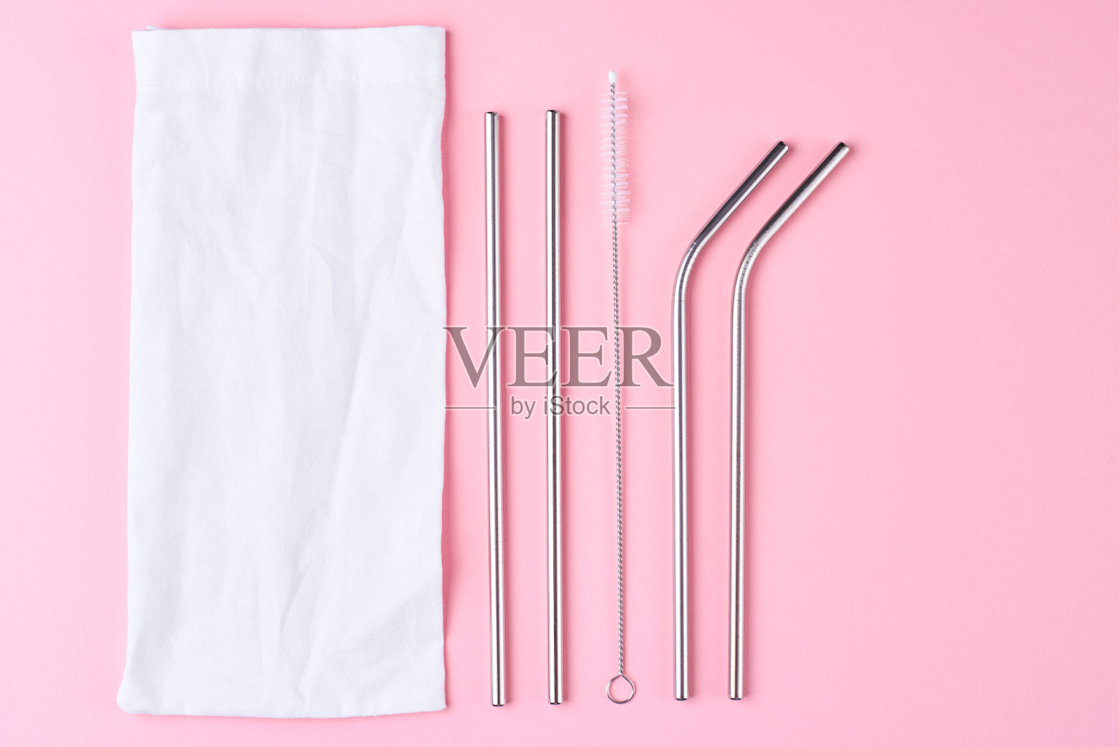 粉红色背景的可重复使用的钢吸管。“零浪费”的概念。照片摄影图片