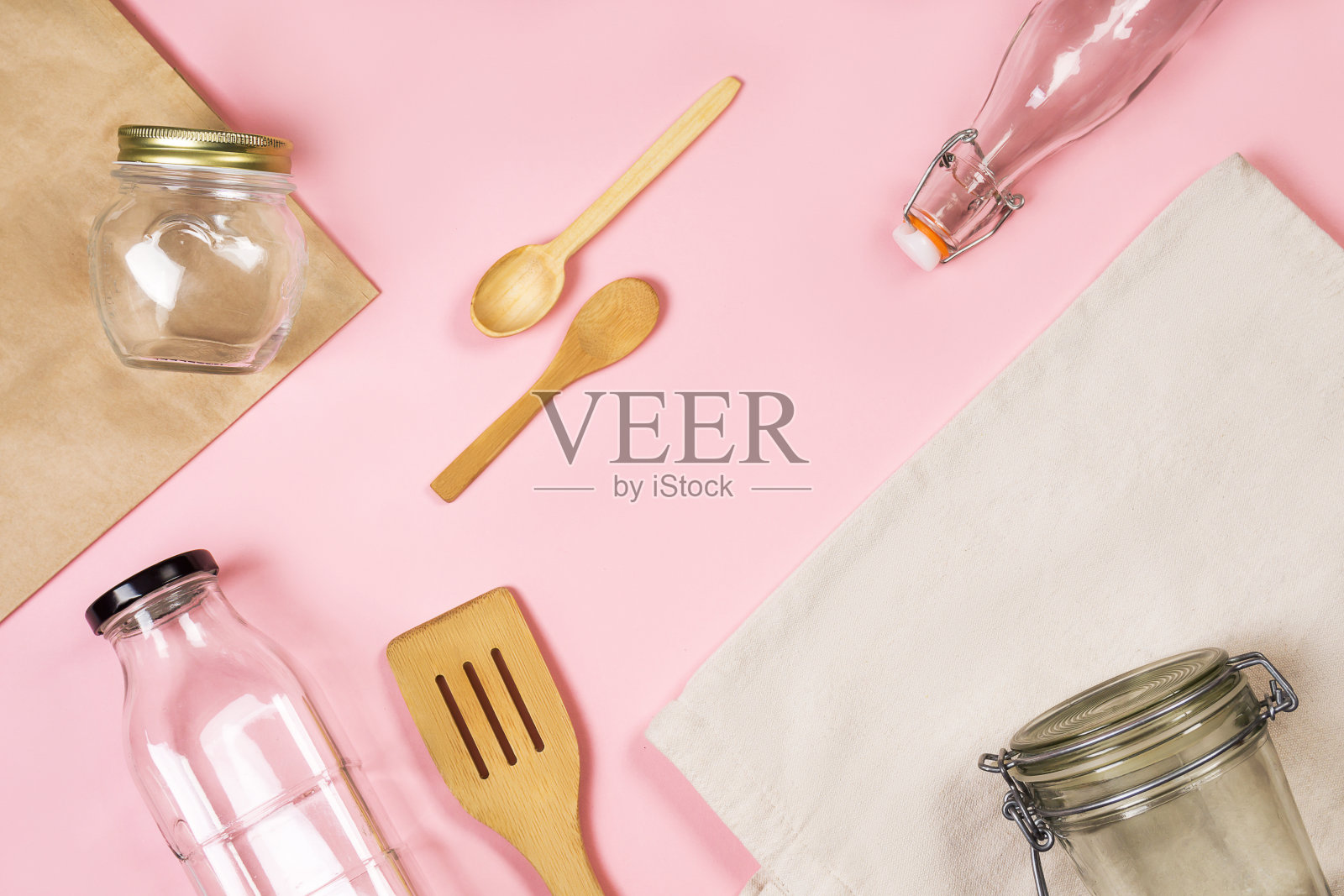 “零浪费”的概念。纺织环保袋,工艺袋,玻璃罐,木制厨房用具在粉红色的背景上环保和重复使用的概念。俯视图或平铺。照片摄影图片