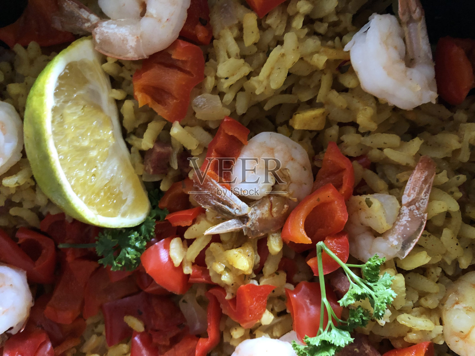 想象一下自制西班牙海鲜饭在平底锅中烹饪,配以短粒白米、藏红花、对虾/虾仁、鸡丁、海鲜贻贝、红辣椒,配以柠檬角和欧芹即可食用照片摄影图片