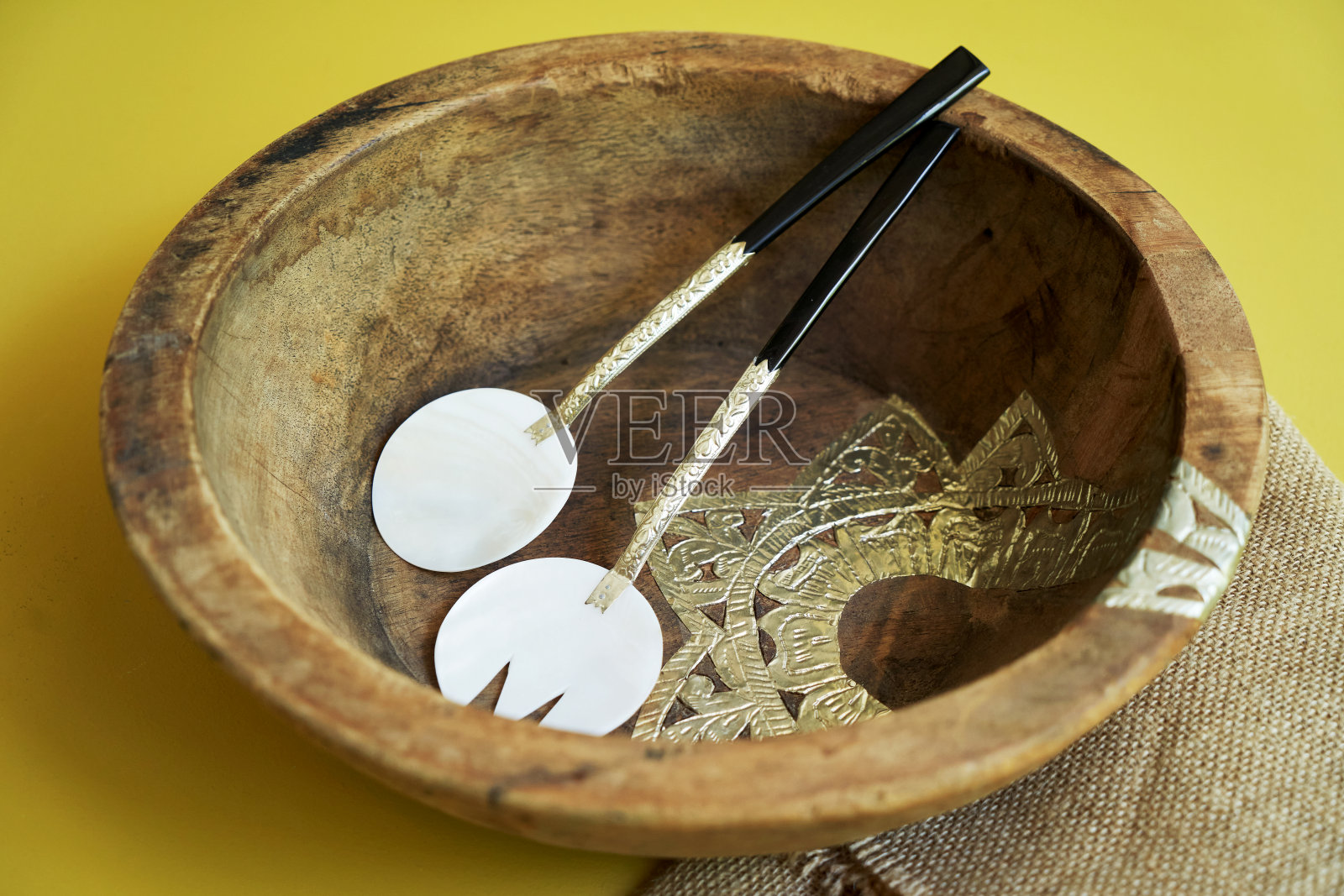 黄色背景的木制盘子和碗。照片摄影图片