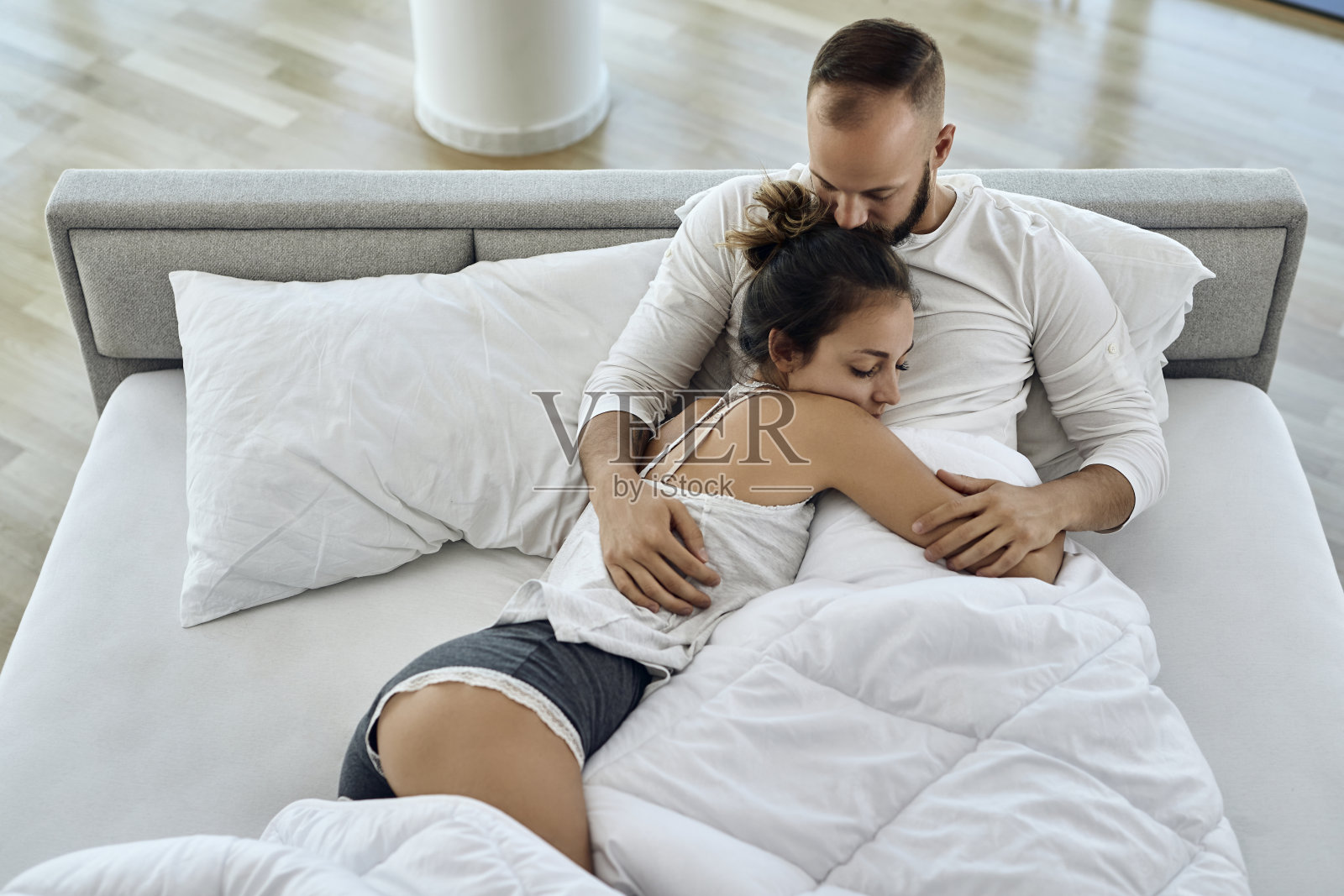 以上的观点,相爱的夫妇放松在床上在早上。照片摄影图片