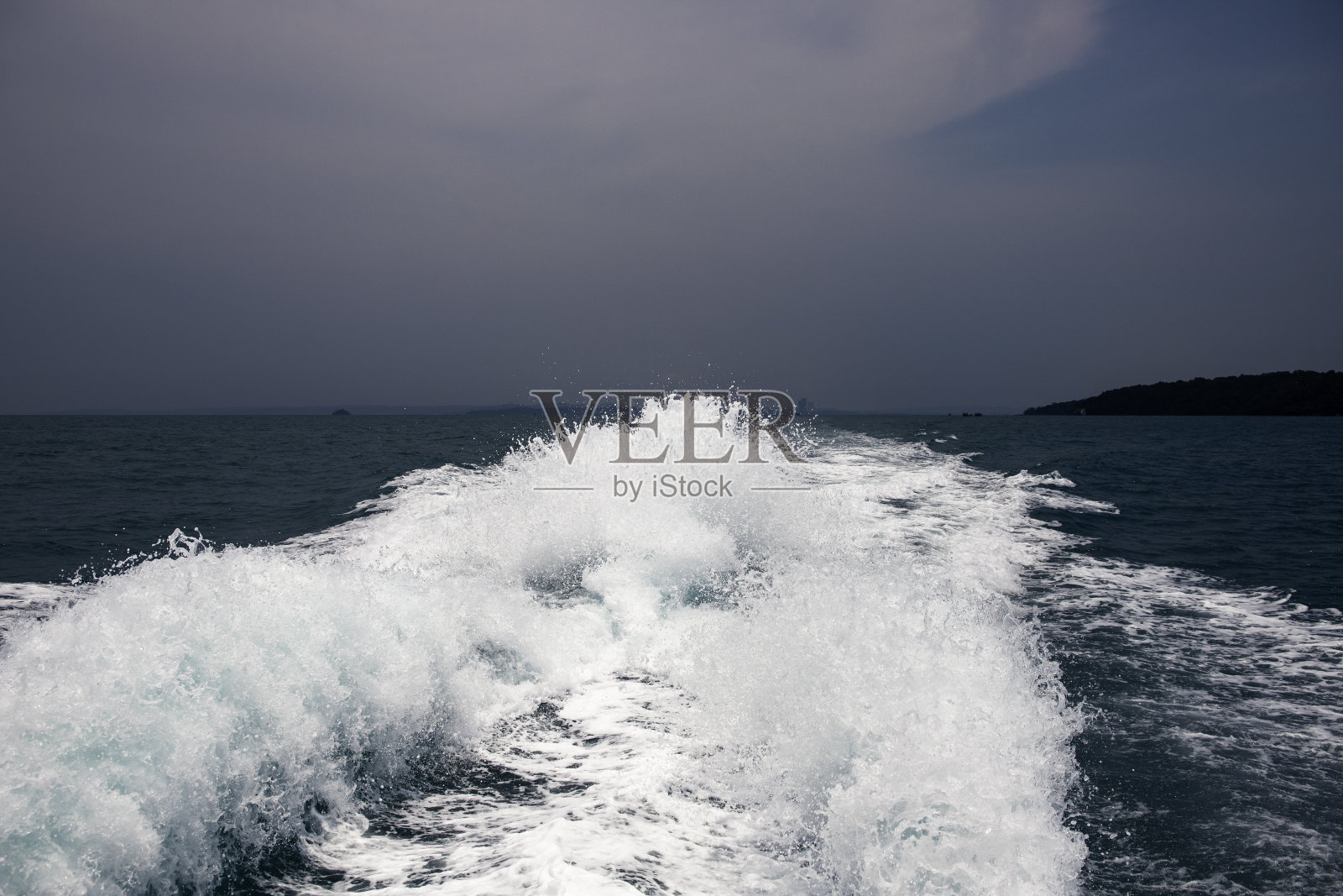 海上旅游船尾照片。暴风雨天的海边风景。海水表面有白色泡沫。摩托艇小道照片摄影图片