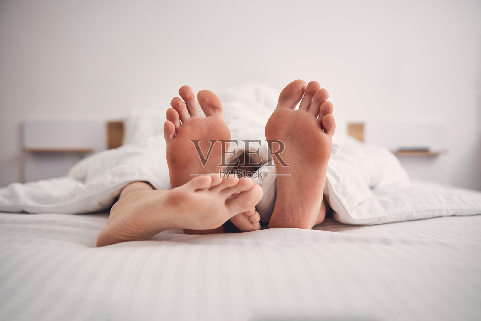 两个人的脚在床上的特写照片摄影图片
