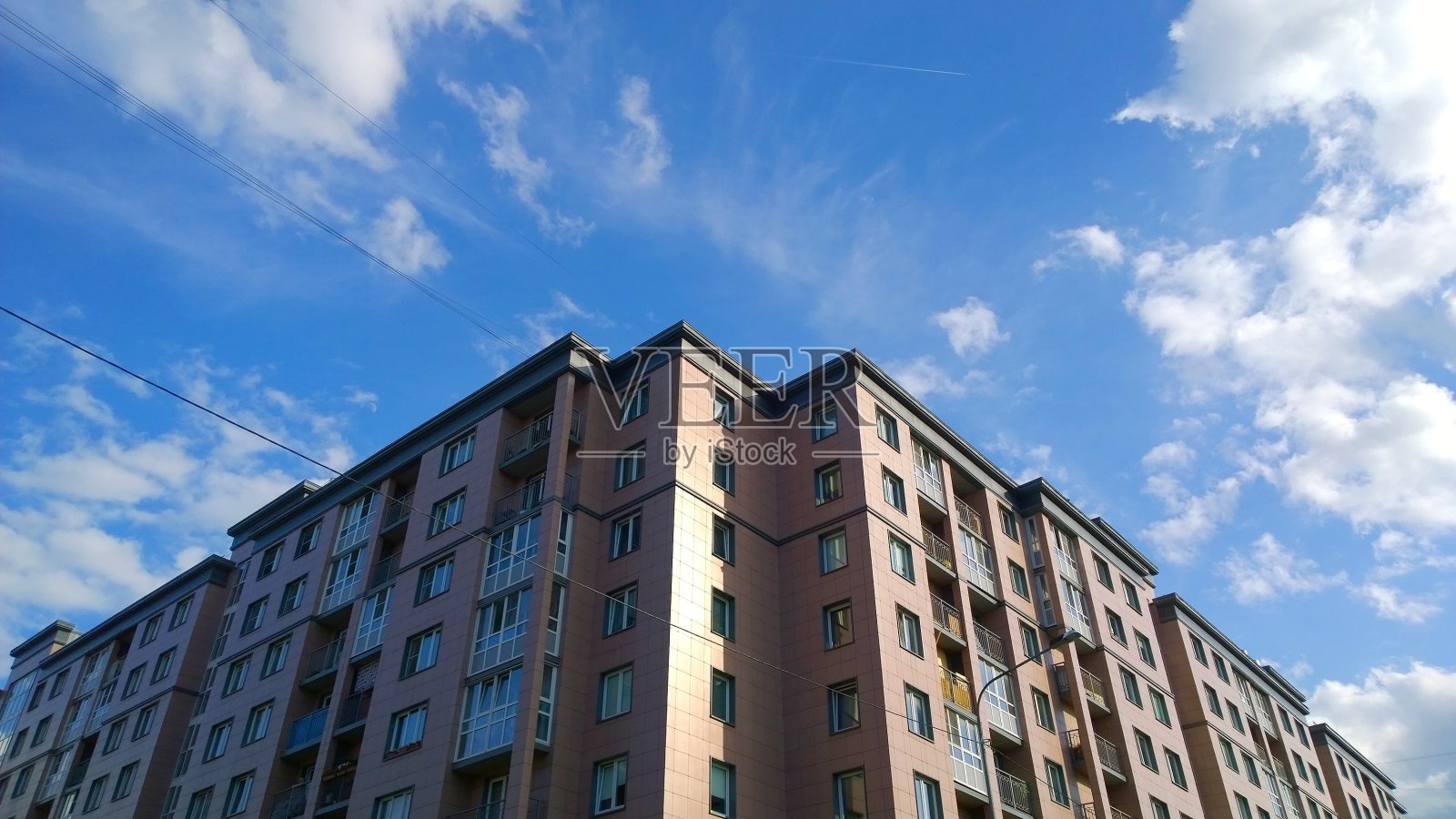 新建多层住宅楼外立面,蓝天背景。房屋共享,房地产投资,经济型公寓买卖租赁及危机保险,住房开发。照片摄影图片