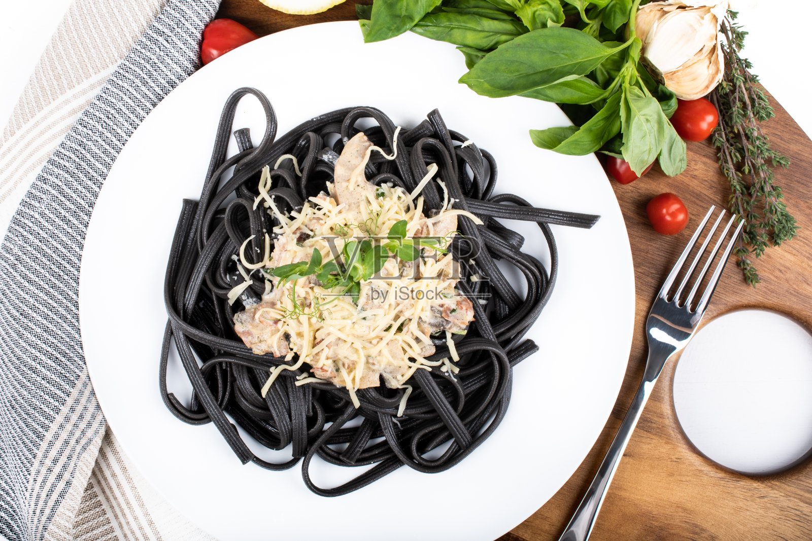 黑色干面条(用墨鱼汁做成的意大利面),配上帕尔玛芝士和火腿酱汁照片摄影图片