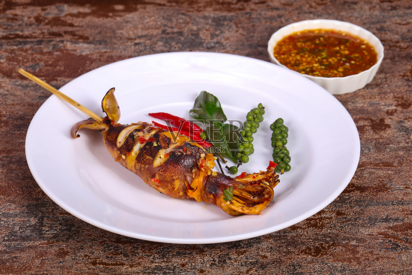 烤鱿鱼配酱汁和香草照片摄影图片