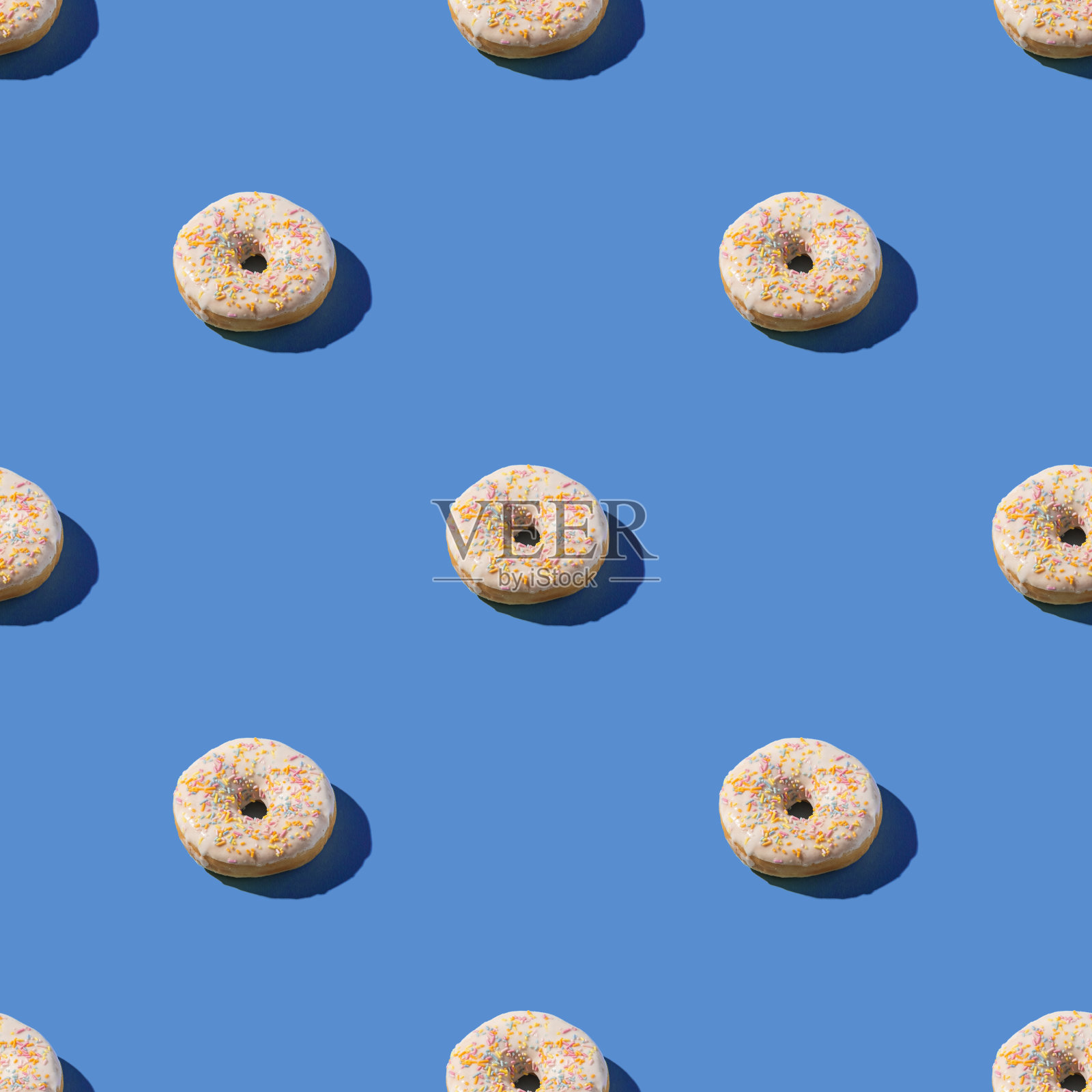 香草白色甜甜圈与点缀,甜釉甜点无缝模式的蓝色背景照片摄影图片