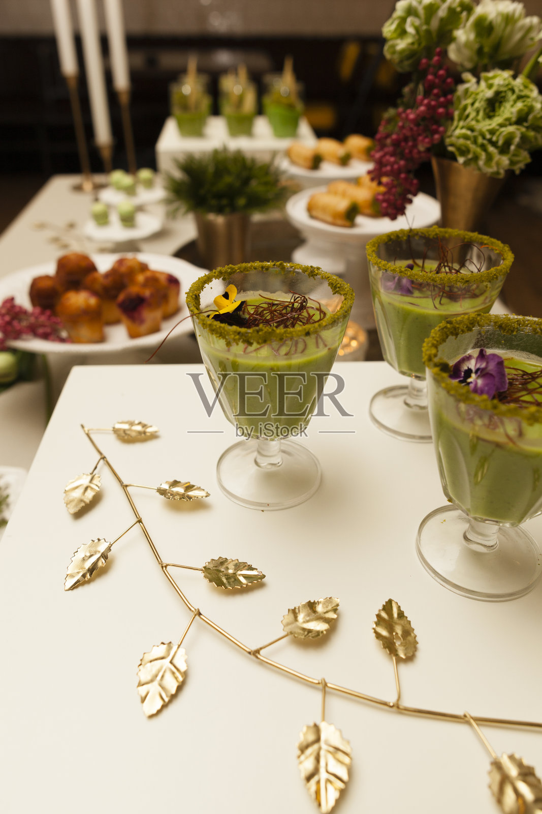 杯子上放着花装饰的鹰嘴豆泥,桌上放着松饼。近距离照片摄影图片