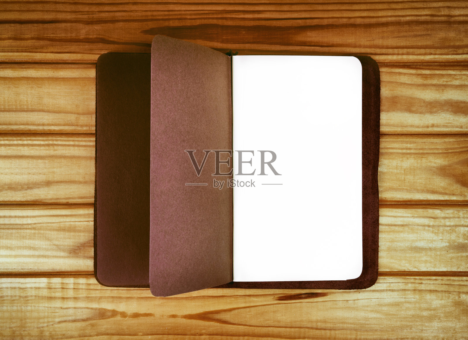 棕色的皮革笔记本和日记本放在一张木桌上。照片摄影图片
