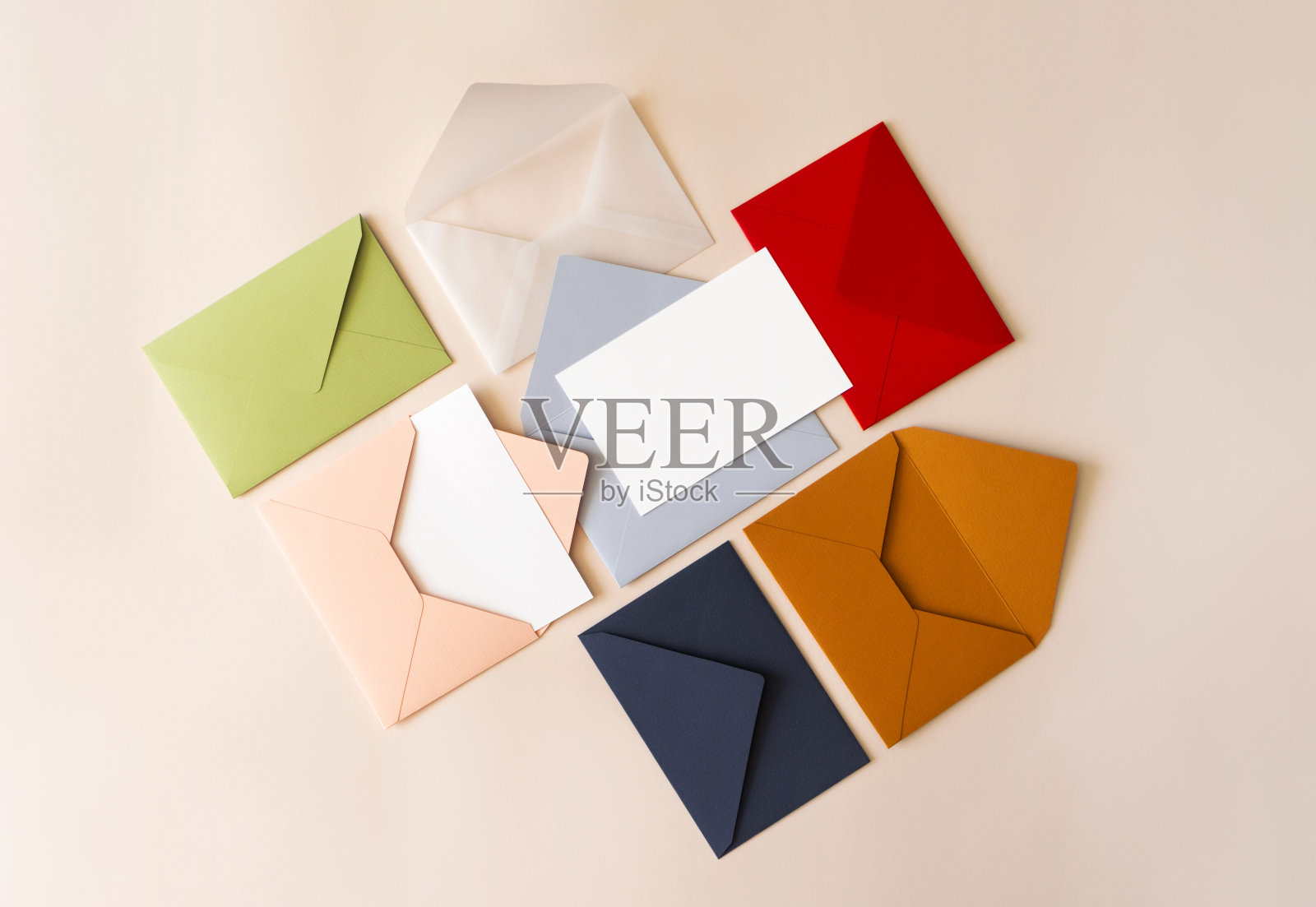 彩色邮件信封在米色背景上平铺,俯视图。邮件的概念。白纸空白模型的信件,贺卡,明信片,邀请照片摄影图片