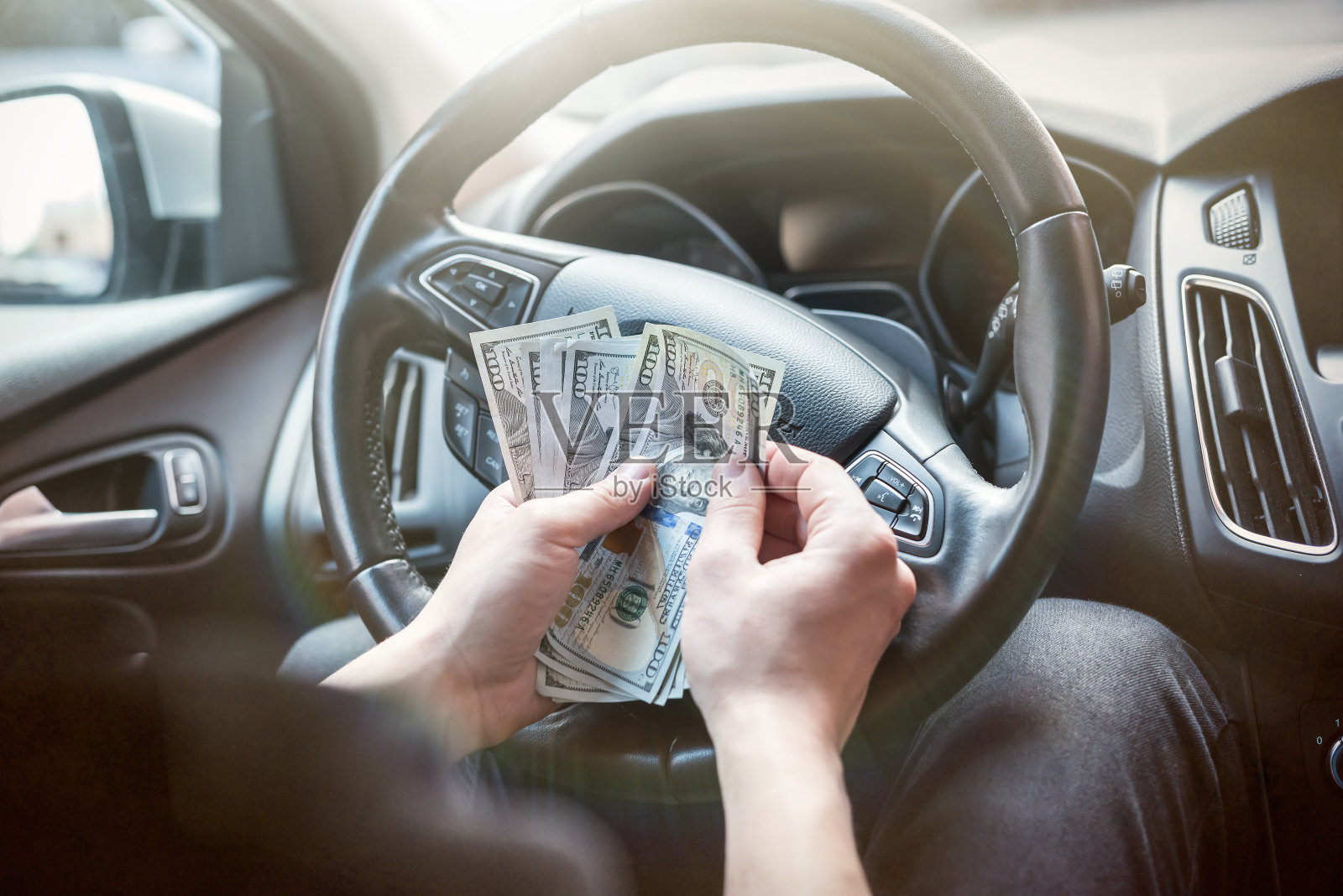 男人手里拿着100美元,男人在车里照片摄影图片
