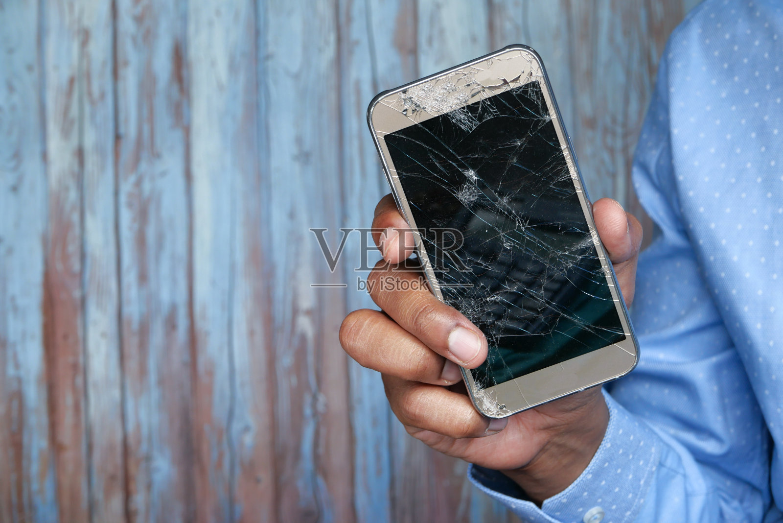男人的手拿着破碎的智能手机的特写照片摄影图片