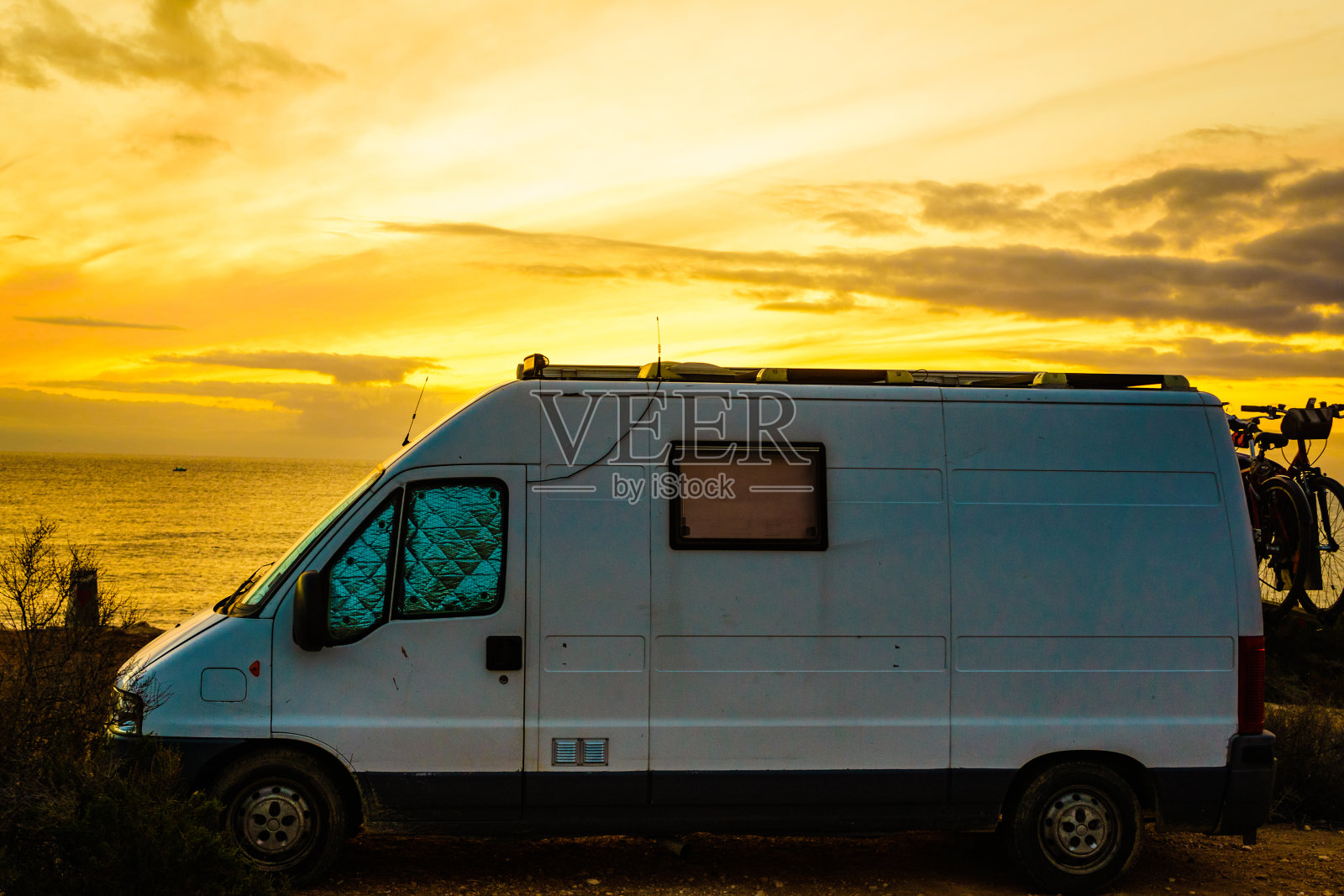 日出时露营车在海滩上照片摄影图片