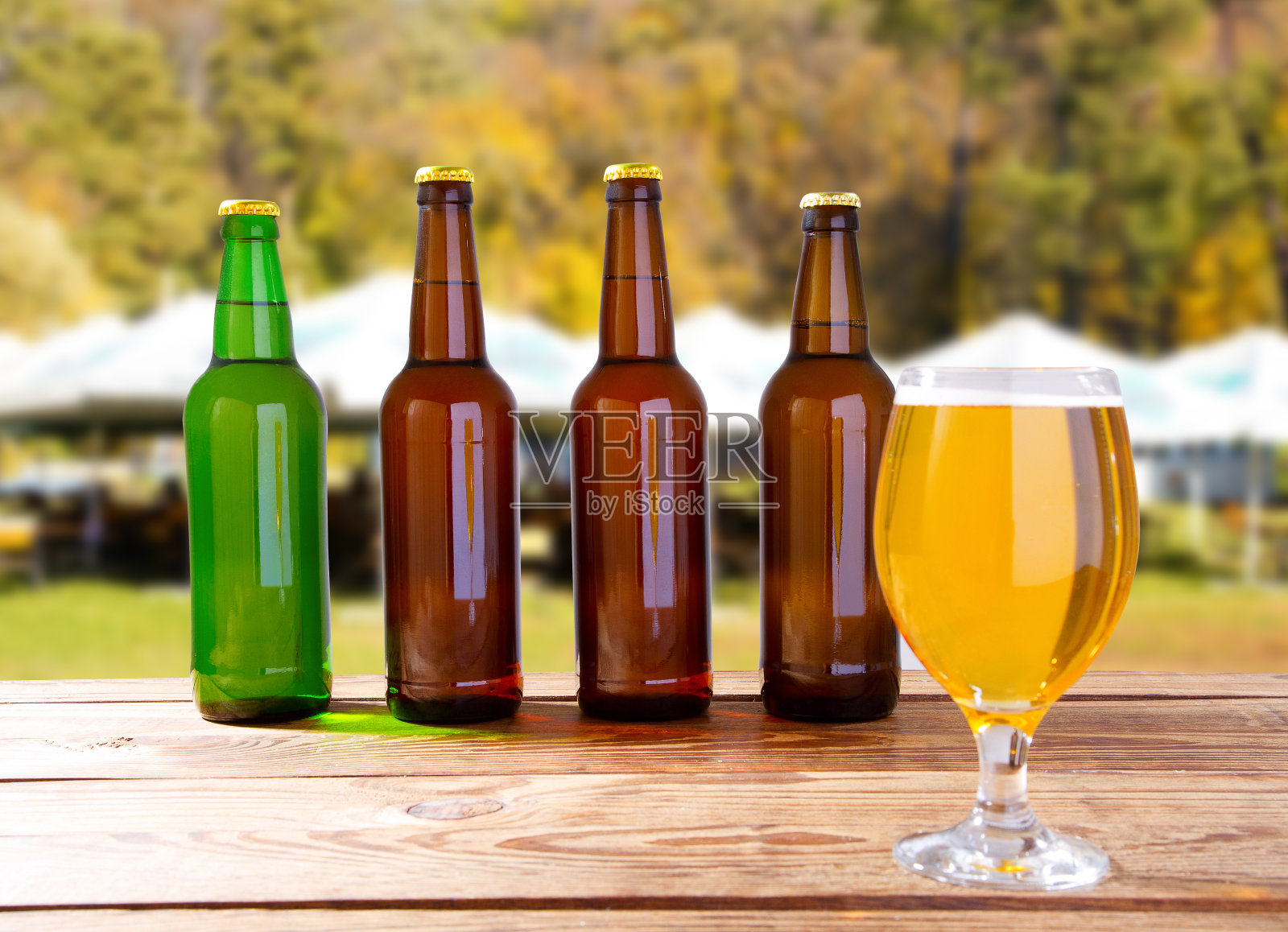 夏日操场上模糊的背景上是啤酒瓶和啤酒杯照片摄影图片