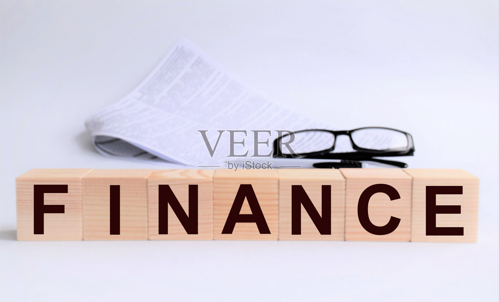 金融概念,题字在木质立方体上以白色为背景,商业、营销、融资,以合同和眼镜为背景照片摄影图片