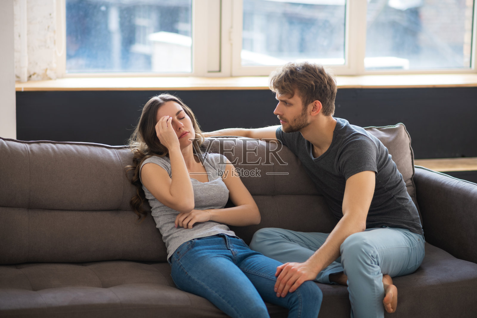 年轻漂亮的女人在丈夫对她说话时看起来压力很大照片摄影图片