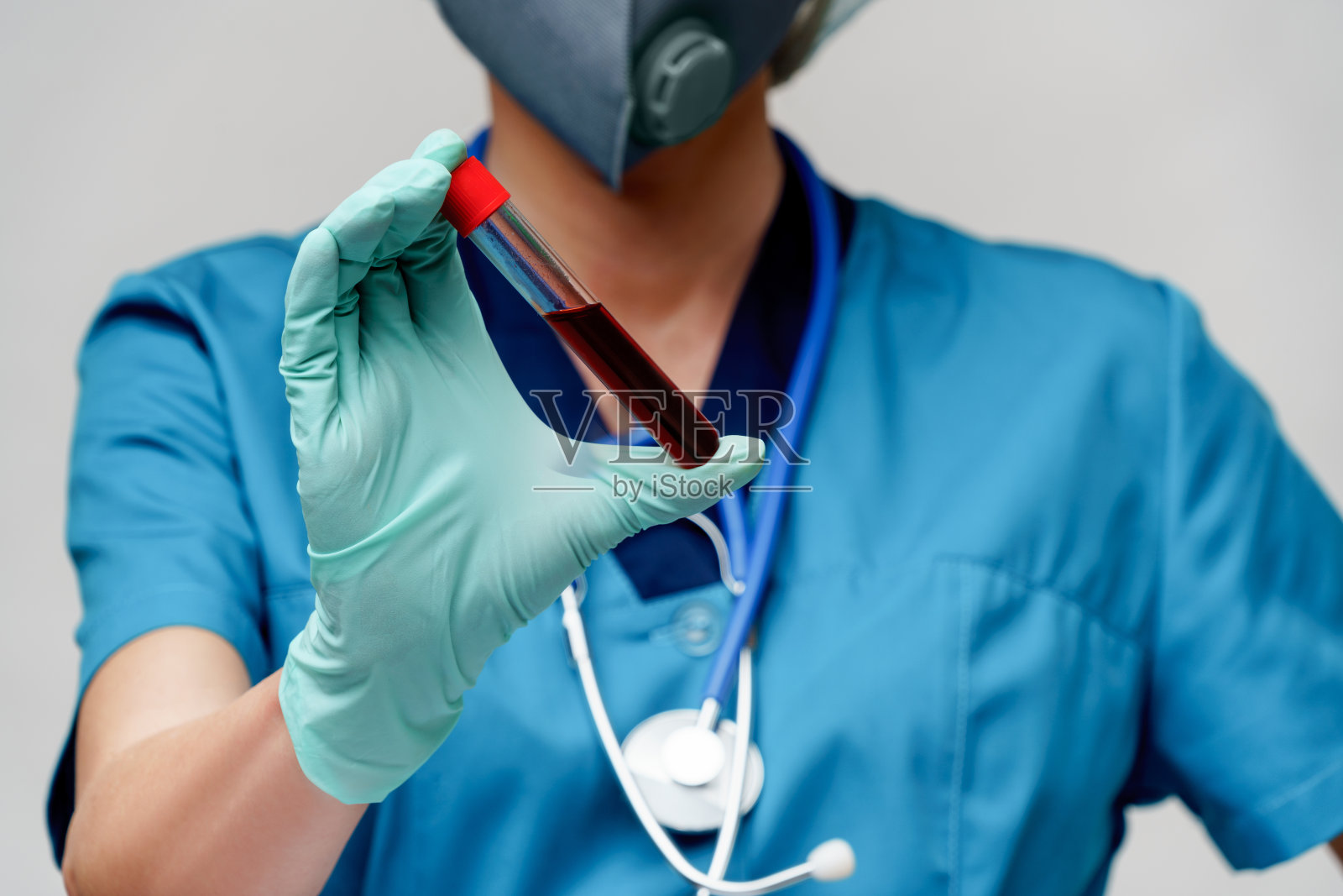 医护人员戴着防护口罩和手套,手持病毒血液试管照片摄影图片