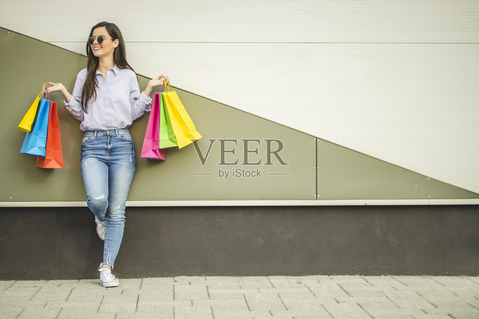 年轻漂亮的女人提着购物袋走路照片摄影图片