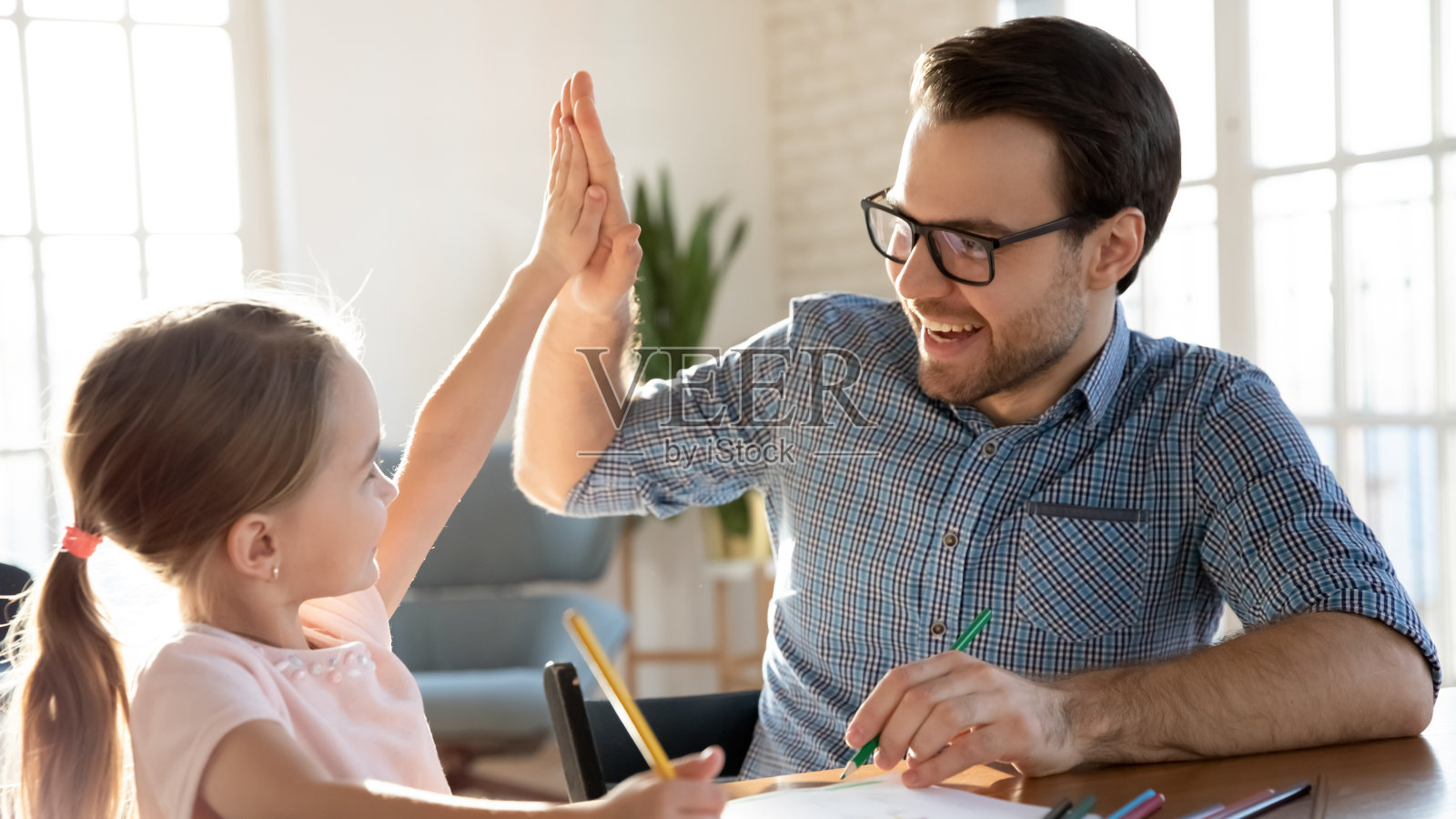 喜出望外的父亲和小女儿在家里庆祝成功照片摄影图片