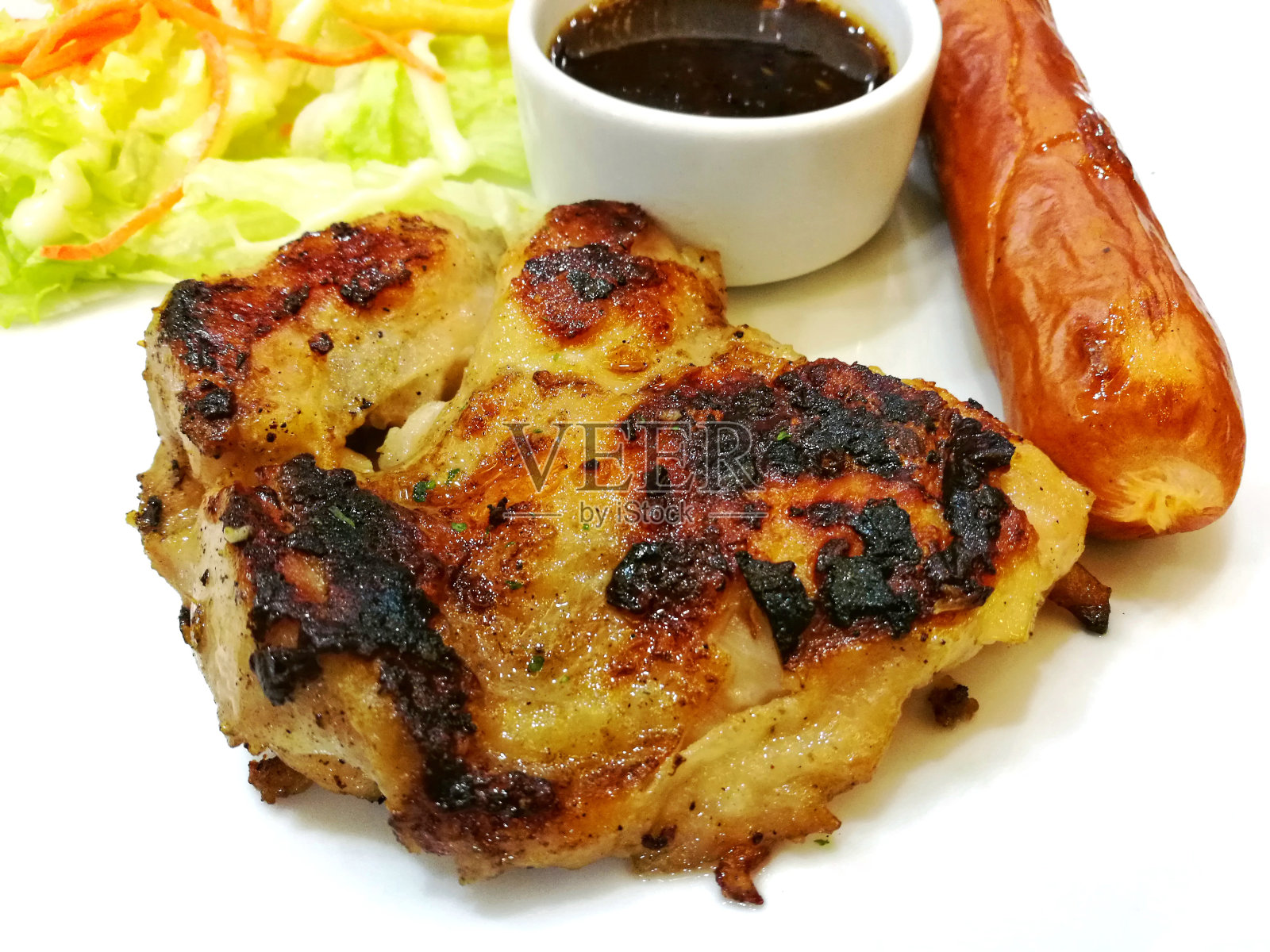 鸡排和猪肉香肠配辣酱。“n照片摄影图片