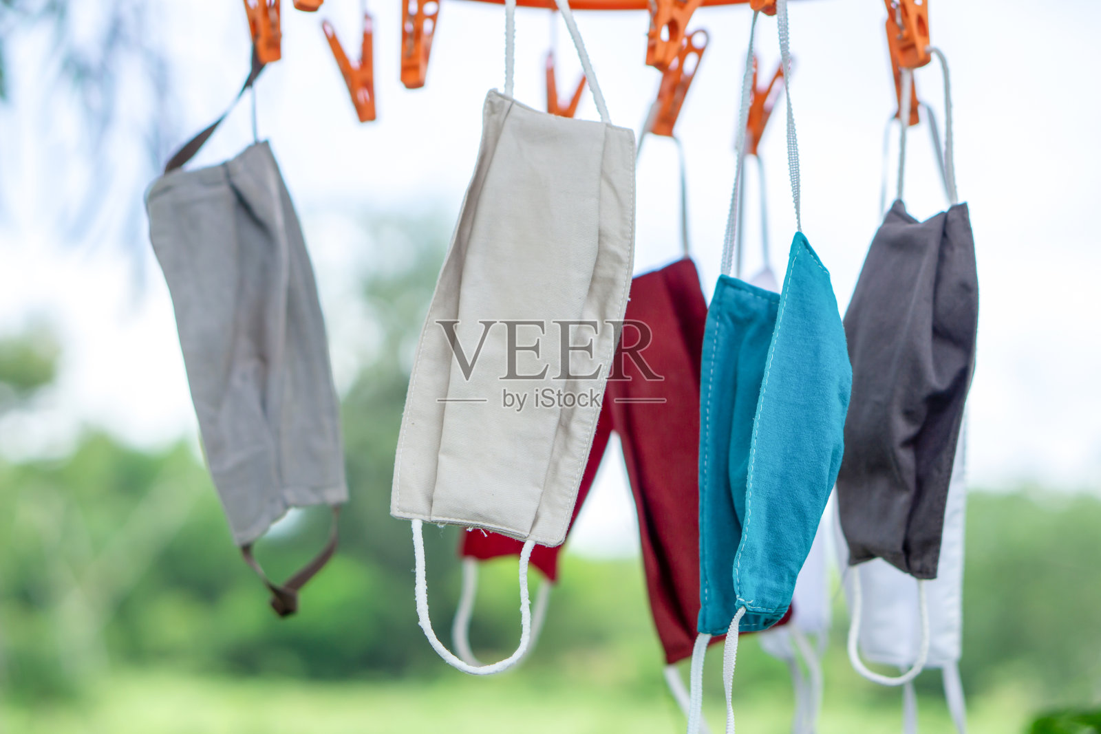 新冠肺炎疫情期间,悬挂在室外的水洗织物防护口罩,新常态生活理念照片摄影图片