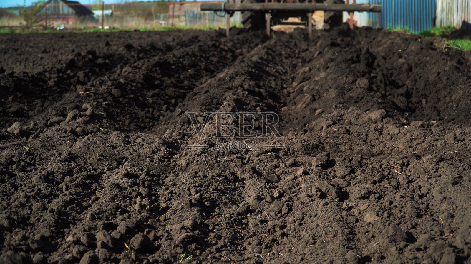 拖拉机在田里犁沟。拖拉机在村里的黑土地里干活照片摄影图片