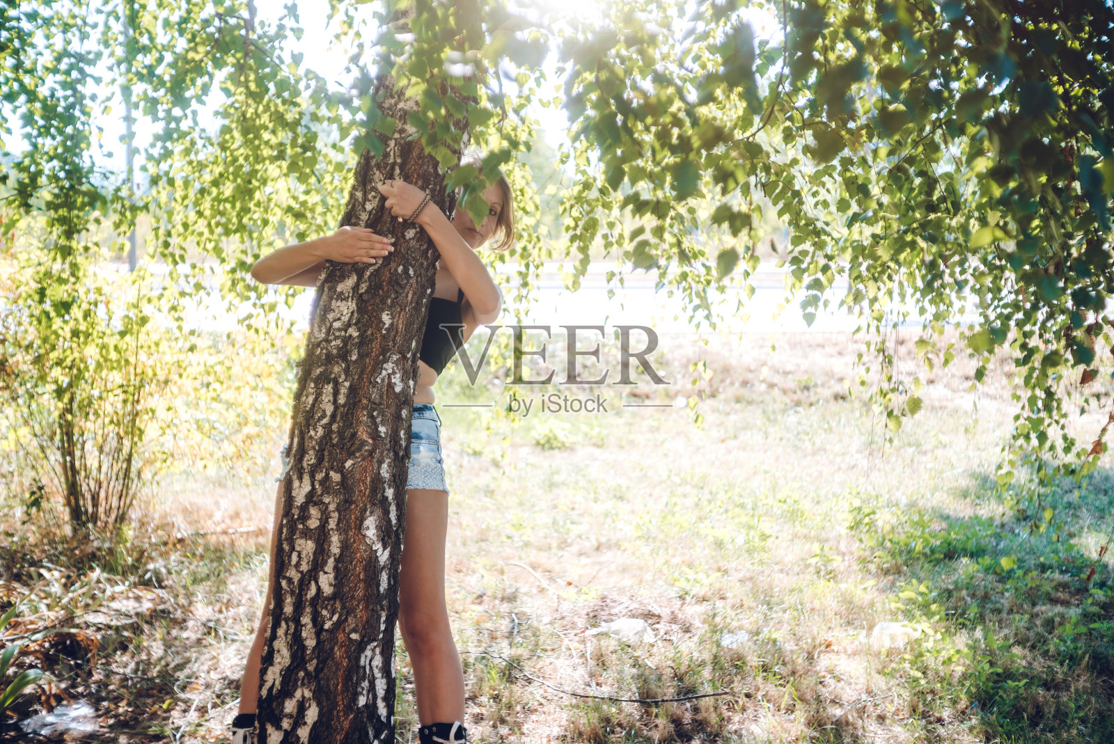 一个女人在公园里拥抱树照片摄影图片
