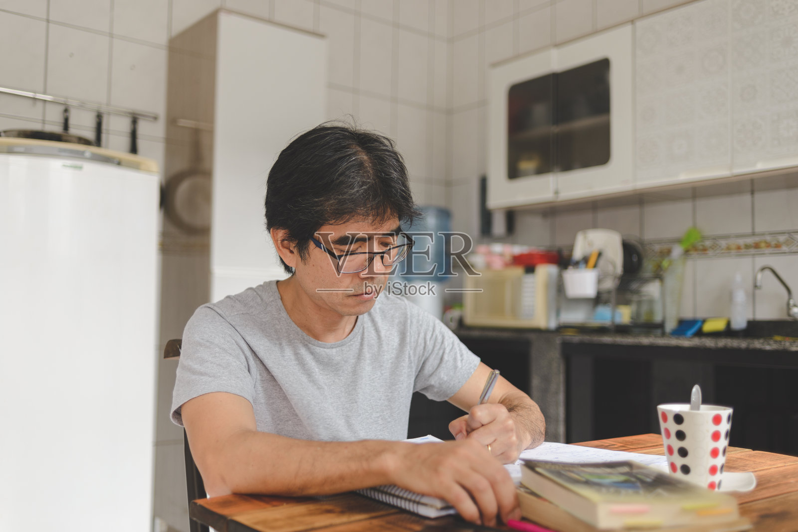 一个在家里写日记的成熟男人照片摄影图片