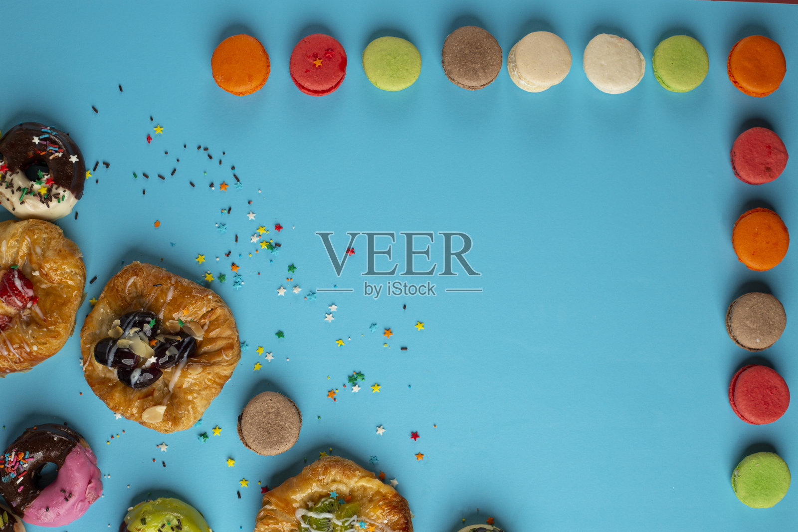 新鲜出炉的传统迷你丹麦酥点,枫糖山核桃、肉桂、苹果、覆盆子混合口味与马卡龙照片摄影图片