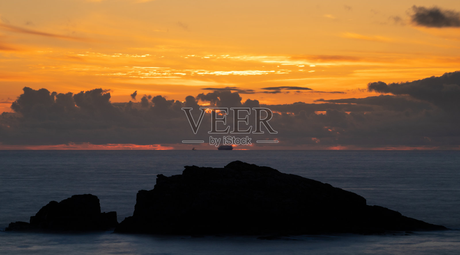 岛屿和船在海上在橙色日落照片摄影图片