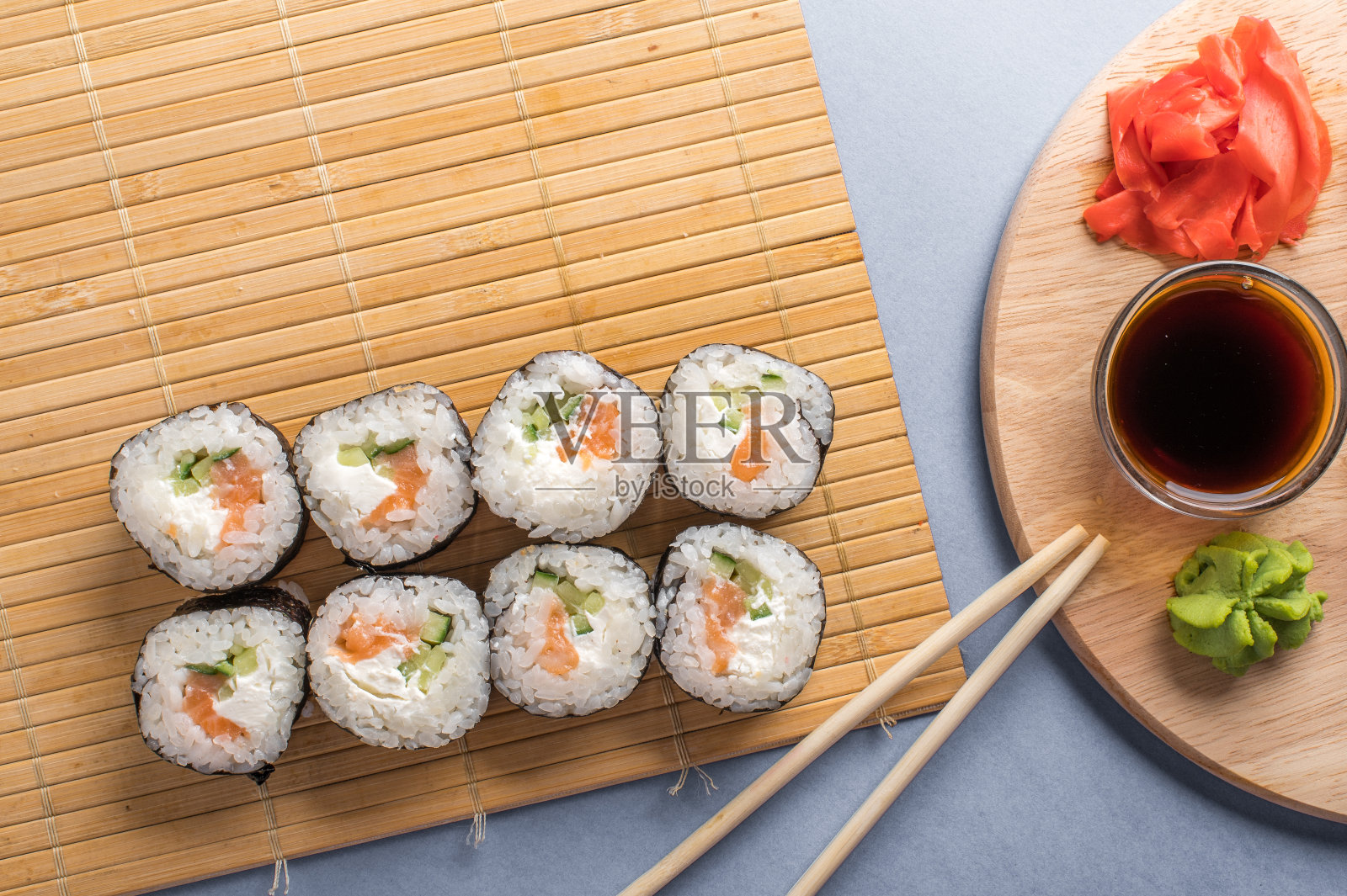 竹席寿司卷,蓝色背景照片摄影图片