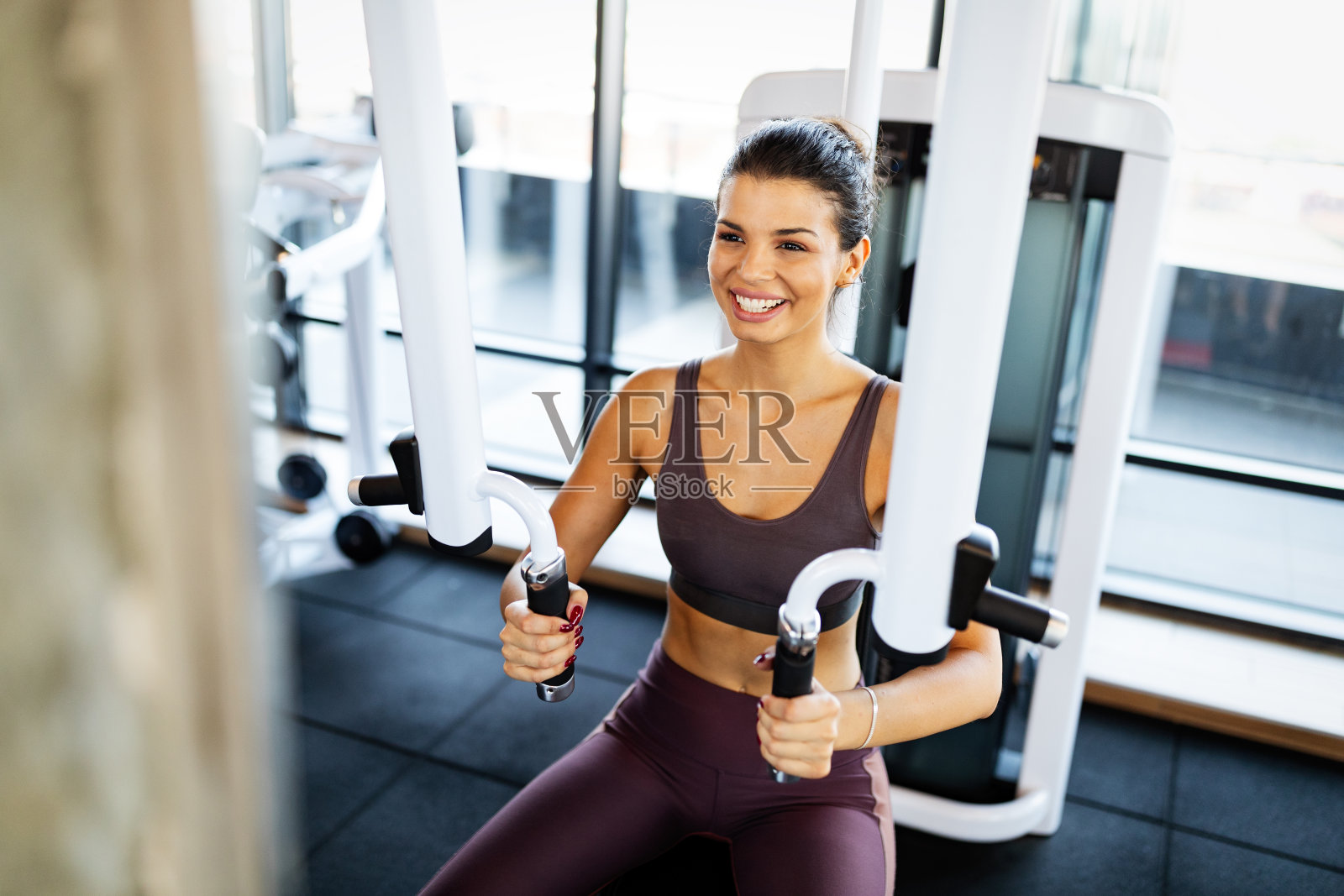 美丽健康的女人在健身房锻炼照片摄影图片