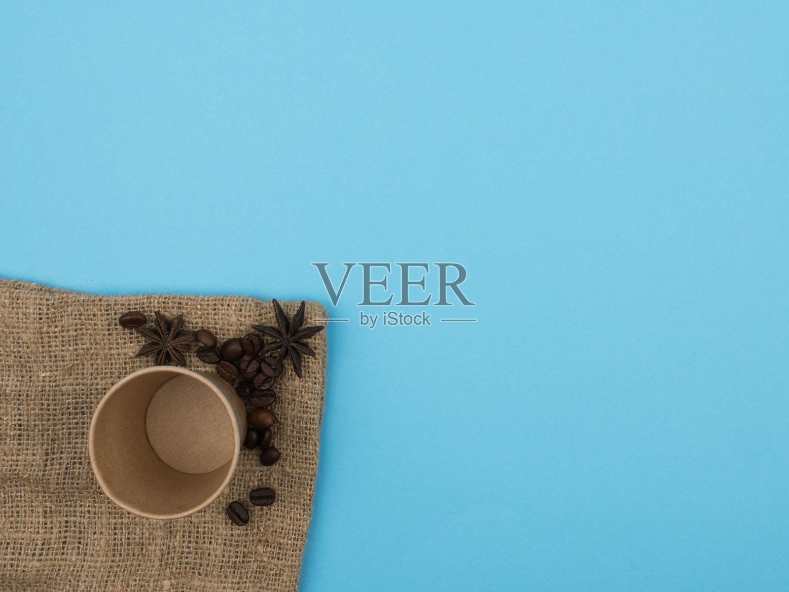 蓝色背景下的咖啡纸杯。照片摄影图片