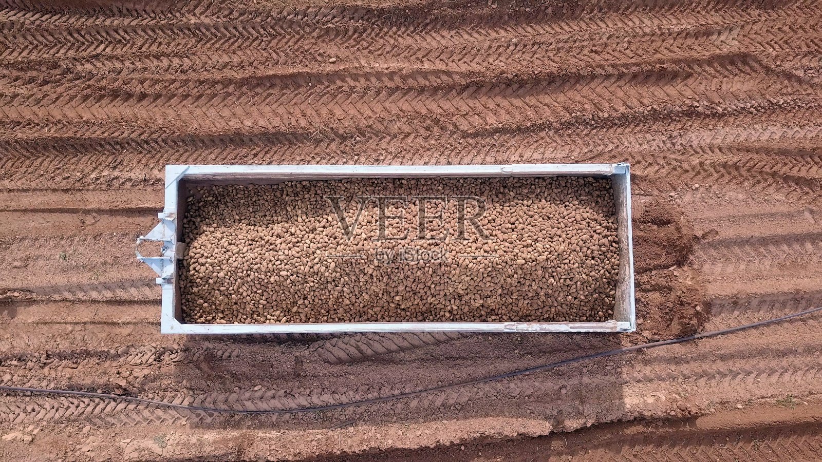 装满土豆的拖车停在耕地上照片摄影图片