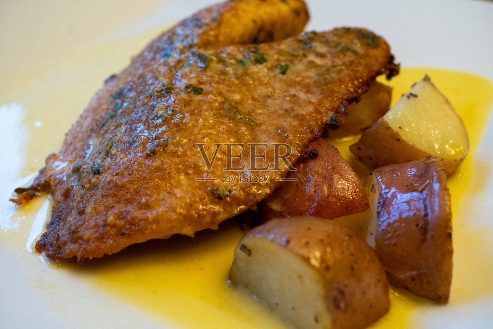 帕玛森罗非鱼配土豆和白牛油照片摄影图片