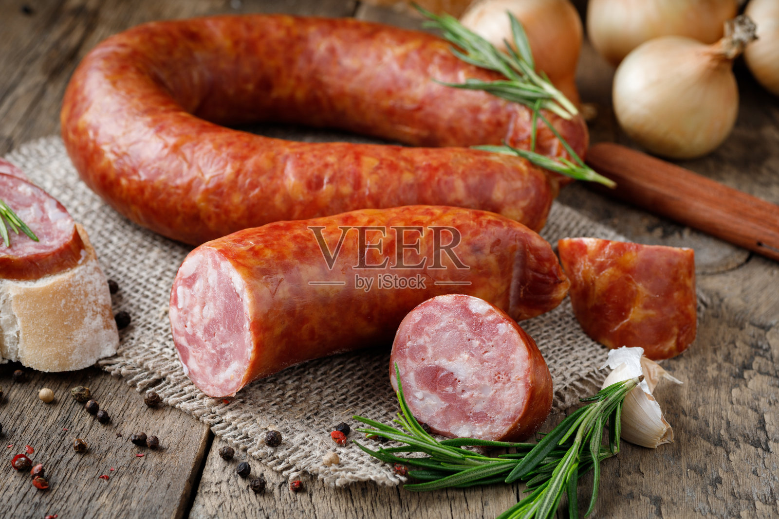 木桌上放着熏香肠。照片摄影图片