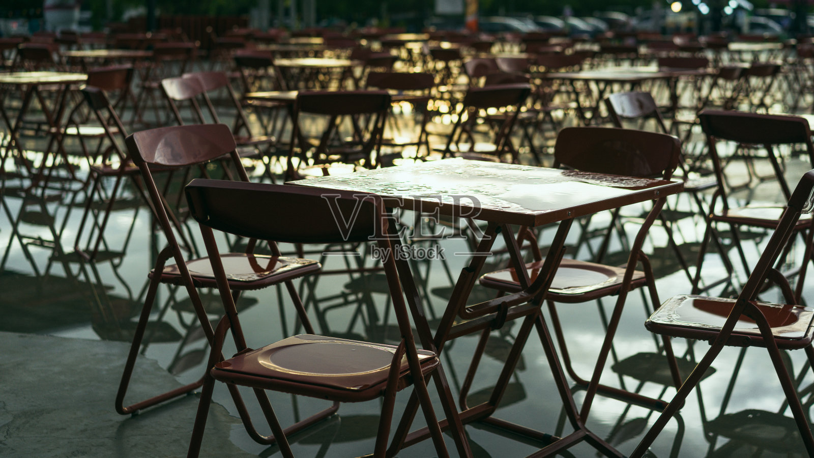 红色的桌子和椅子在户外。咖啡馆。雨后城市概念。照片摄影图片