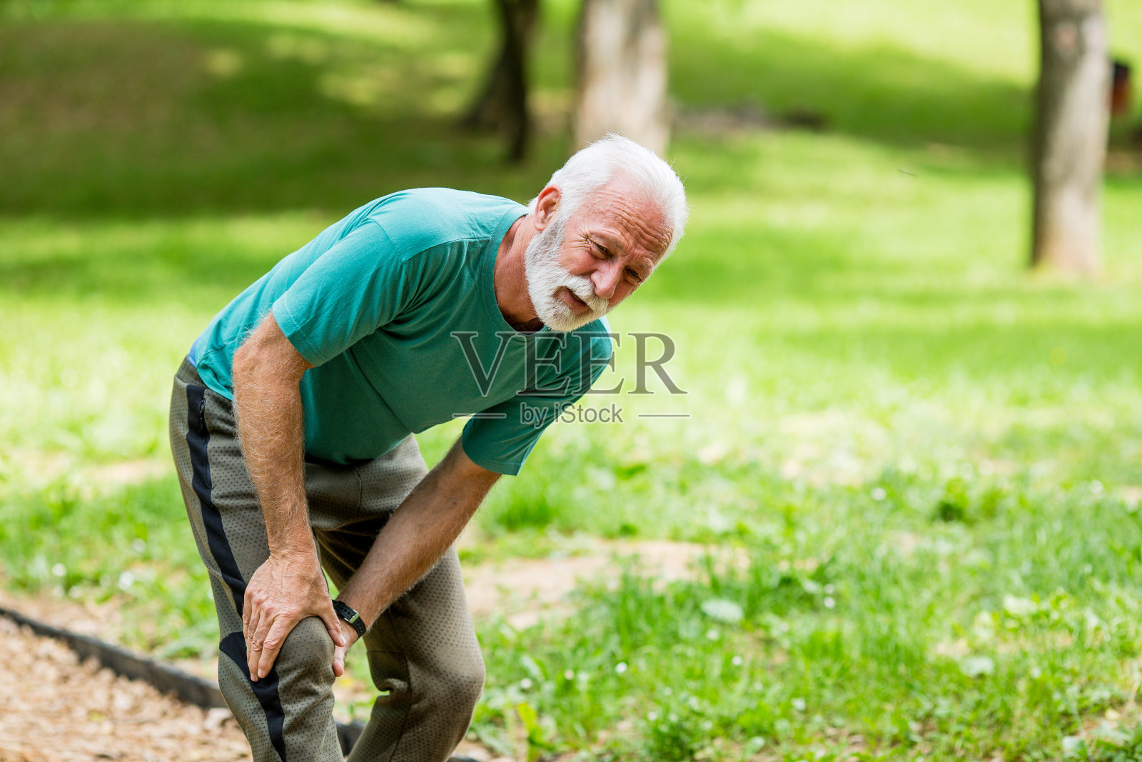 膝盖疼痛的资深跑步者照片摄影图片