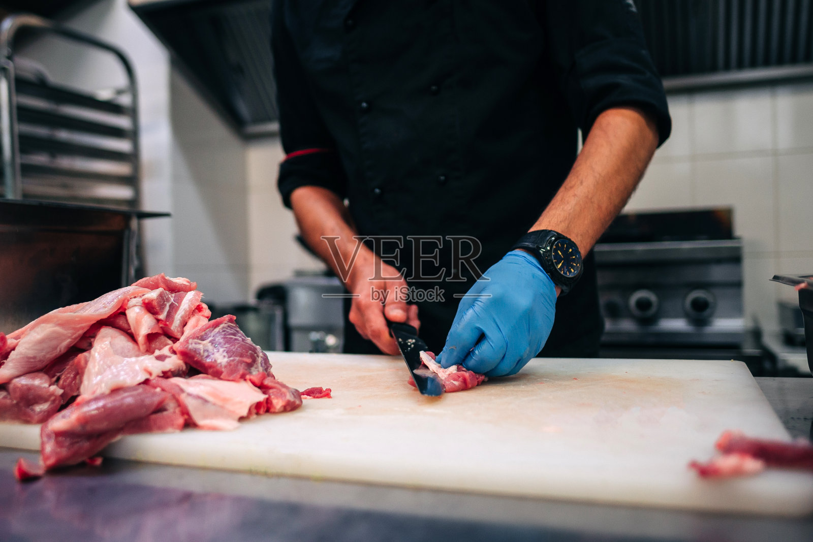男厨师在餐厅厨房切生排骨照片摄影图片