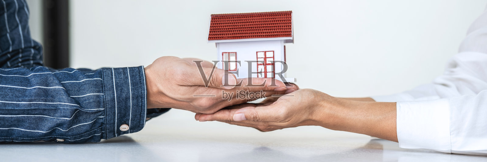 房地产经纪人向客户提交和咨询决策签订保险单协议、房屋模型、有关抵押贷款报价和房屋保险照片摄影图片