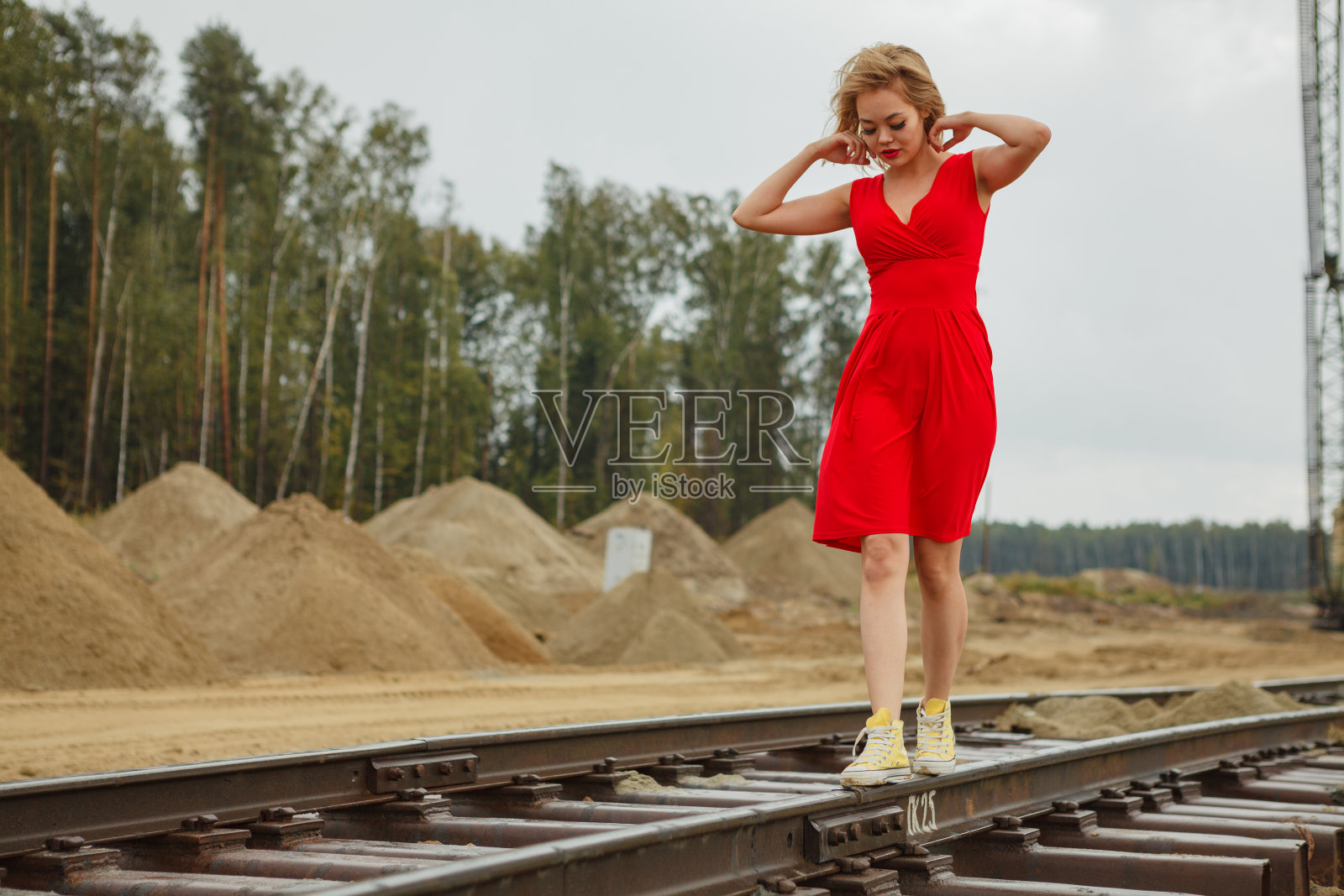 年轻的亚洲女孩穿着红色衣服在铁路上跳舞照片摄影图片