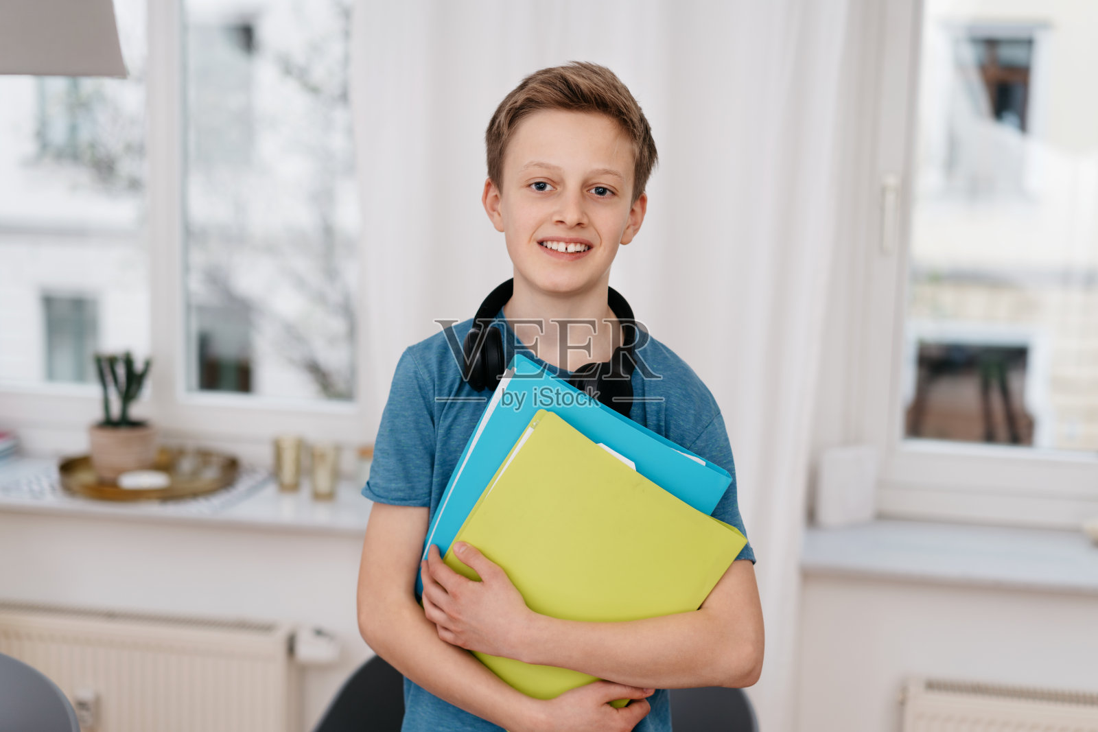 迷人的少年拿着五颜六色的文件夹照片摄影图片