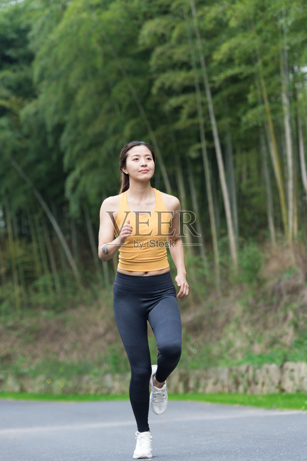 一位年轻的亚洲妇女正在跑步照片摄影图片