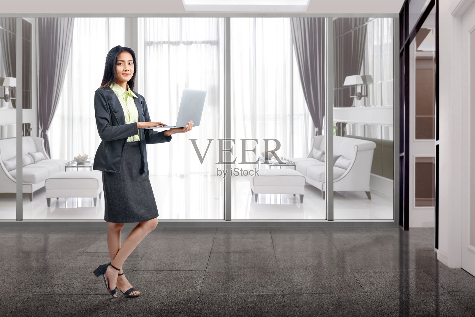 亚洲女商人在家里用笔记本电脑工作时站立照片摄影图片